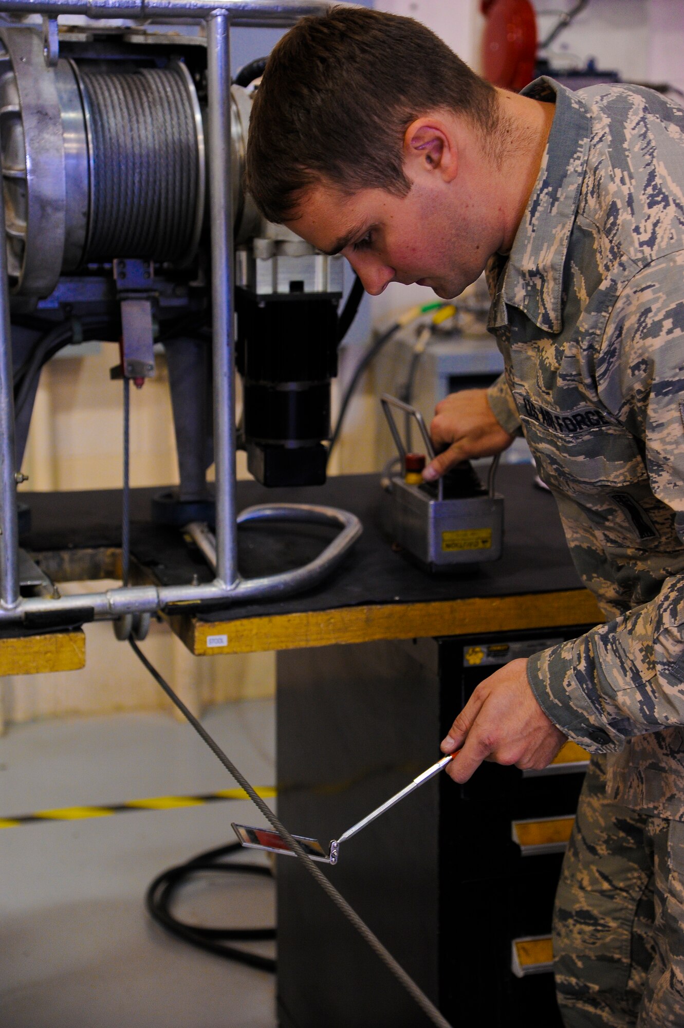 Senior Airman Justin Rollins, 341st Missile Maintenance Squadron facility maintenance technician, troubleshoots a guidance missile maintenance platform life support cable during a training session at Malmstrom Air Force Base’s 3-Bay Hangar Aug. 19. The cable must be routinely inspected to ensure there is no damage or frayed threads. (U.S. Air Force photo/Airman 1st Class Collin Schmidt)