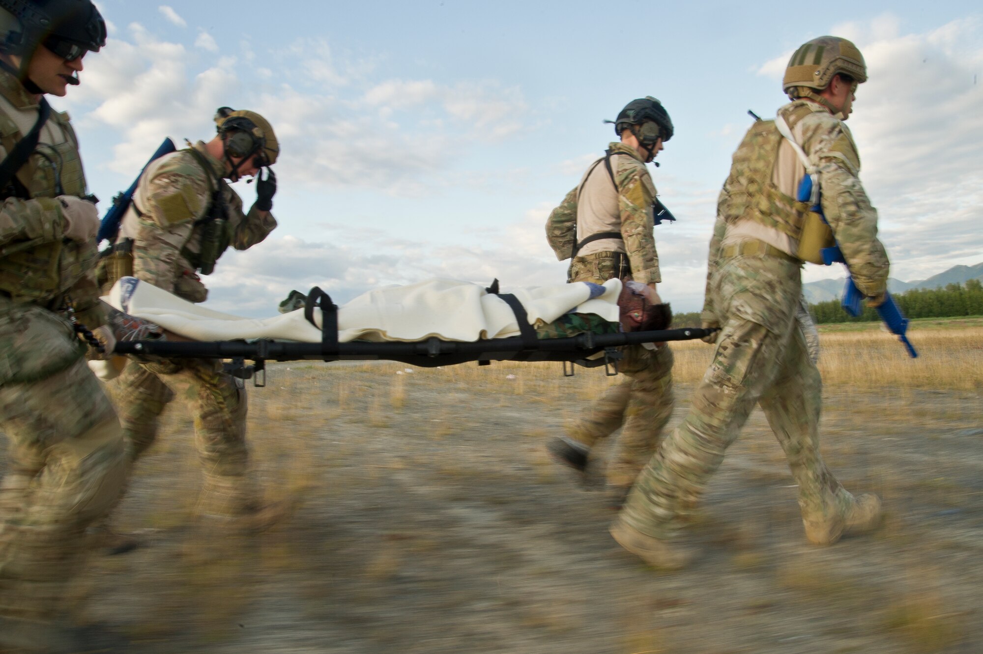 U.S. Air Force pararescuemen also known as PJs (para-jumpers) from the, Alaska Air National Guard Joint Base Elmendorf-Richardson, Alaska, and (Pararescue/Guardian Angels) from Davis Monthan AFB, Tucson, Ariz., transport a wounded body during simulated mass casualty combat training scenario July 30, 2014. The PJs are responsible for providing emergency and lifesaving services to military members and civilians in both peacetime and combat environments, they go behind enemy lines before anyone else to set on a drop zone/air field and help call in fire support.