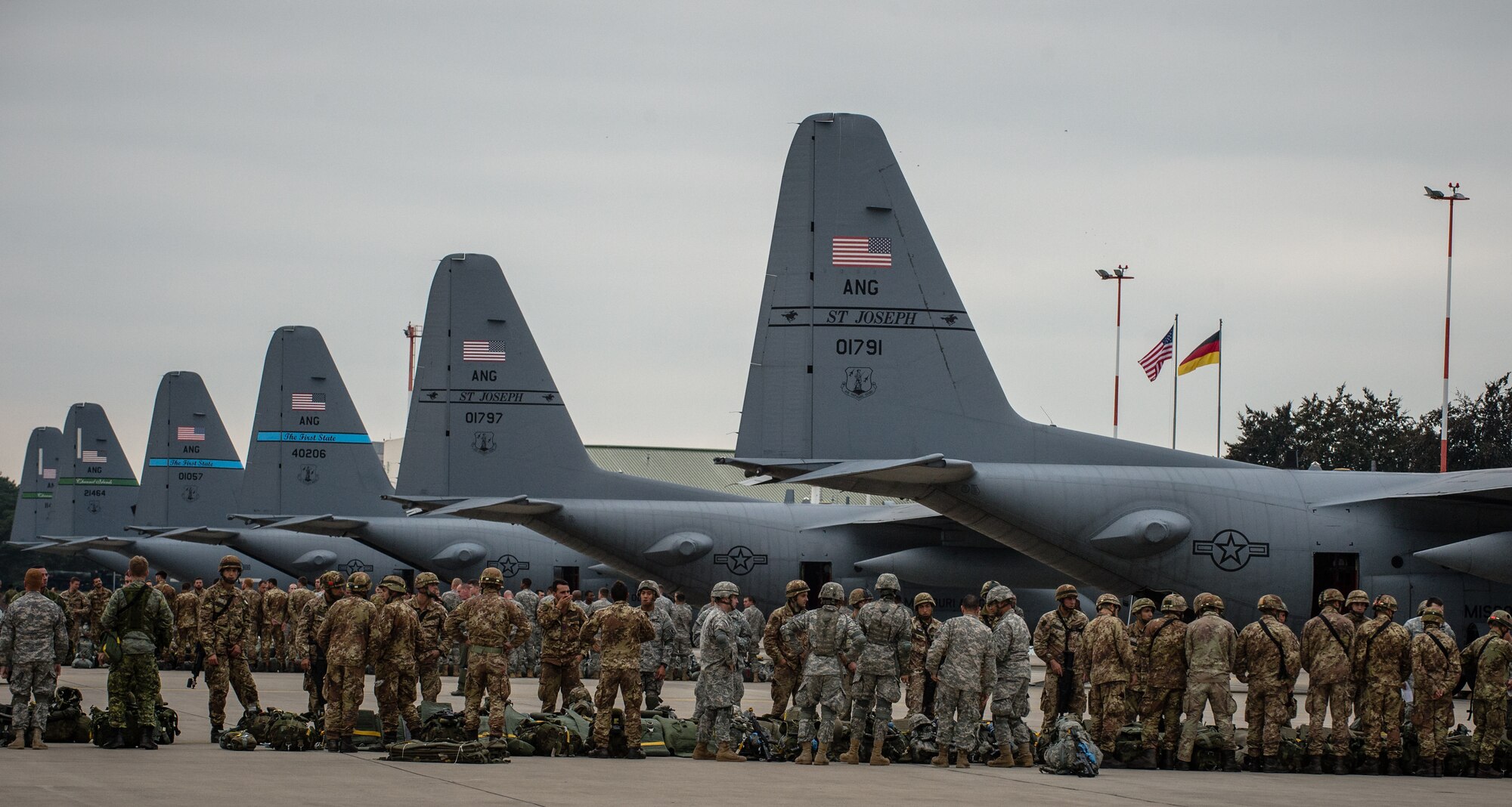 U.S. Army and Italian Esercito soldiers lineup in preparation to put on their parachutes during static line training as part of a training aspect of Steadfast Javelin II on Ramstein Air Base, Germany, Sept. 3, 2014. The exercise prepares U.S., NATO Allies and European security partners to conduct unified land operations through the simultaneous combination of offensive, defensive, and stability operations appropriate to the mission and the environment, and to sustain interoperability with partner nations. (U.S. Air Force photo/Airman 1st Class Jordan Castelan)