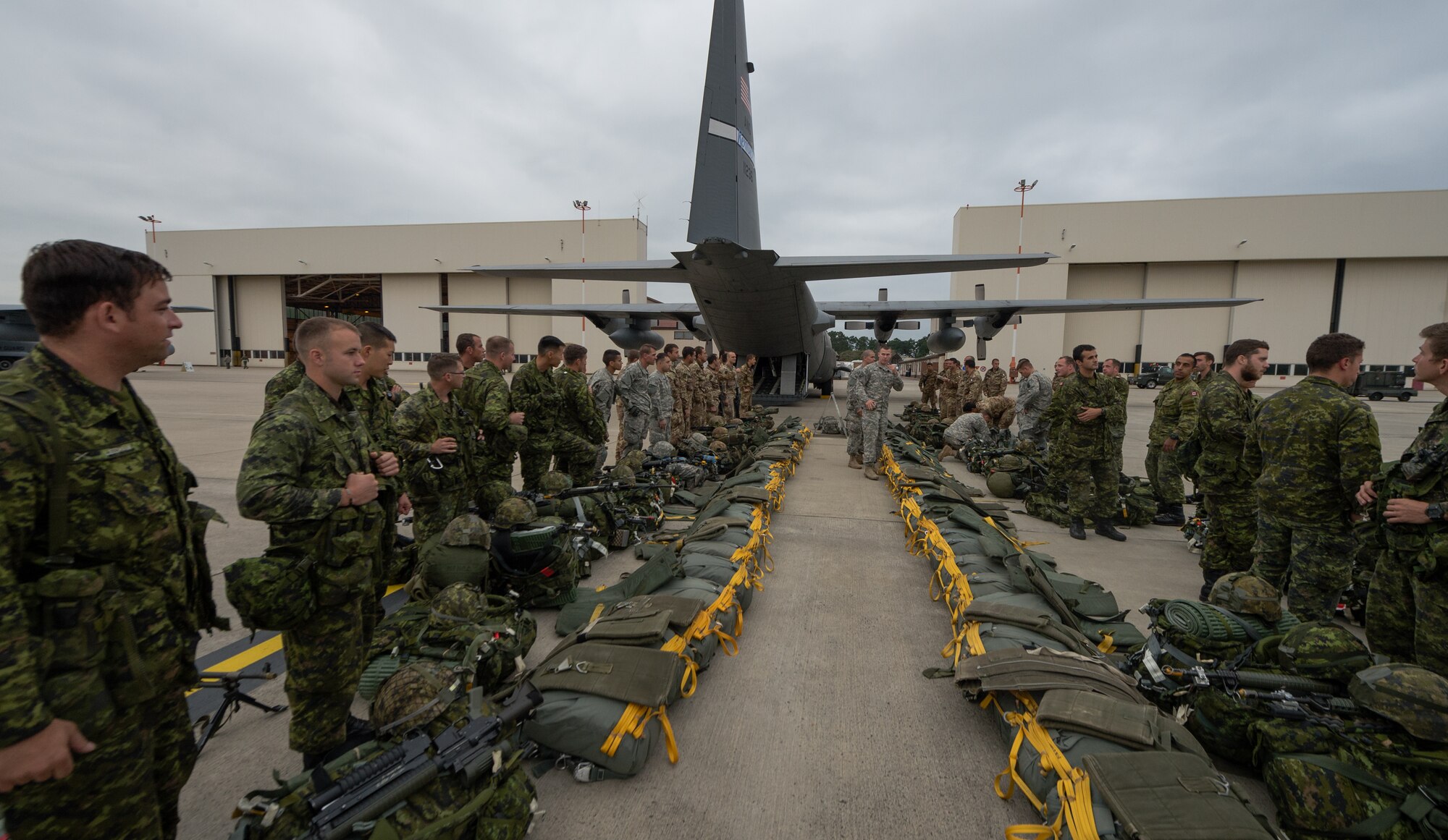 U.S. Army, Royal Canadian Regiment and Italian Esercito soldiers lineup in preparation to put on their parachutes during static line training as part of a training aspect of Steadfast Javelin II on Ramstein Air Base, Germany, Sept. 3, 2014. The exercise prepares U.S., NATO Allies and European security partners to conduct unified land operations through the simultaneous combination of offensive, defensive, and stability operations appropriate to the mission and the environment, and to sustain interoperability with partner nations. (U.S. Air Force photo/Airman 1st Class Jordan Castelan)