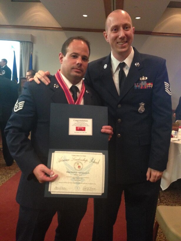 (Left) Staff Sgt. Paul Carapucci, 926th Security Forces Squadron assistant squad leader, is presented with an Airman Leadership School certificate by Tech. Sgt. Benjamin Stoeckl at a graduation ceremony Aug. 14. Carapucci was a distinguished graduate of ALS class 14-F. ALS prepares Airmen to supervise and lead Air Force work teams to support the employment of air and space power. Nellis ALS graduates an average of 420 students per year. (courtesy photo)