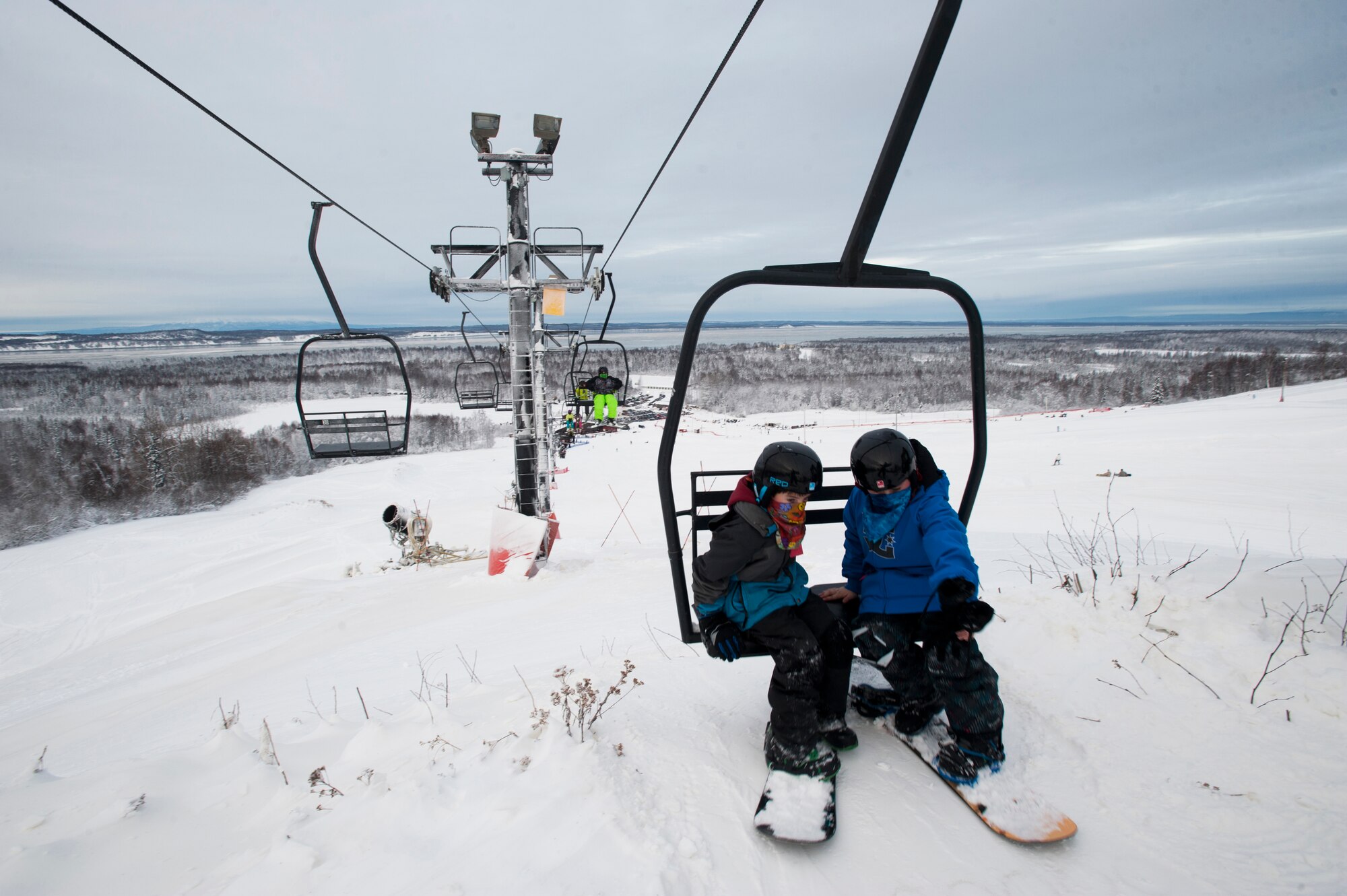Two children prepare to get off a ski lift at Hilberg Ski Area on Joint Base Elmendorf-Richardson, Alaska, Dec. 20, 2013. During the winter, children should wear the proper winter attire while playing outside and participating in outdoor recreational activities. The Army Community Service Center provides a program called ‘Koats for Kids,’ through which military members, retirees and their families can donate gently used winter clothing to others who are unable to afford new winter attire. (U.S. Air Force photo/Staff Sgt. Robert Barnett)