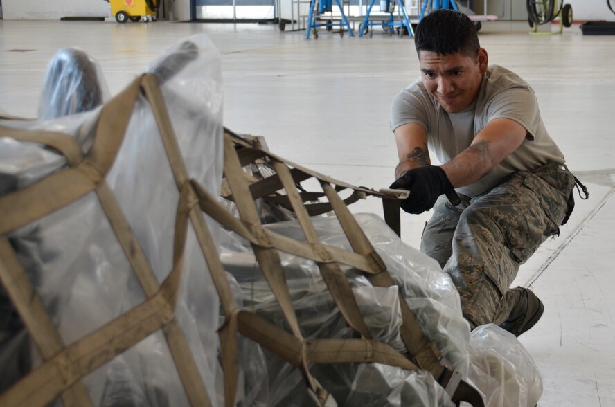 Staff Sgt. Emmanuel Montanez, 144th Maintenance Squadron crew chief, tightens the top netting on a pallet inside the base hangar Aug. 28, 2014. The 144th Fighter Wing is scheduled to attend the Weapons System Evaluation Program in Tyndall Air Force Base, Fla. (California Air National Guard photo by Airman 1st Class Klynne Pearl Serrano/Released)