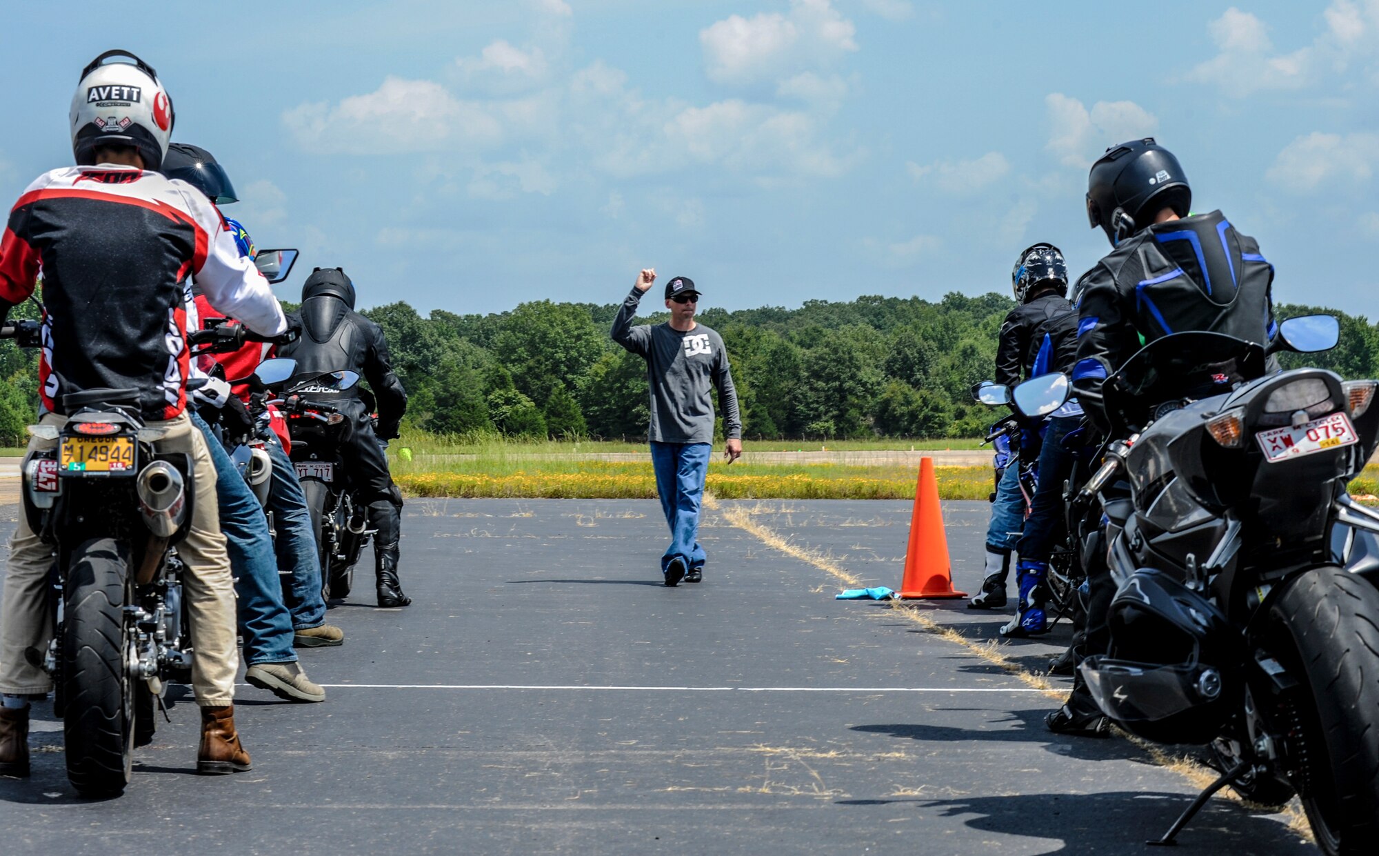 A rider coach signals Team Little Rock members when to start a motorcycle safety course Aug. 25, 2014, at Little Rock Air Force Base, Ark. The Kevin Schwantz rider’s course taught advanced motorcyclists street performance techniques. (U.S. Air Force photo by Airman 1st Class Harry Brexel)  