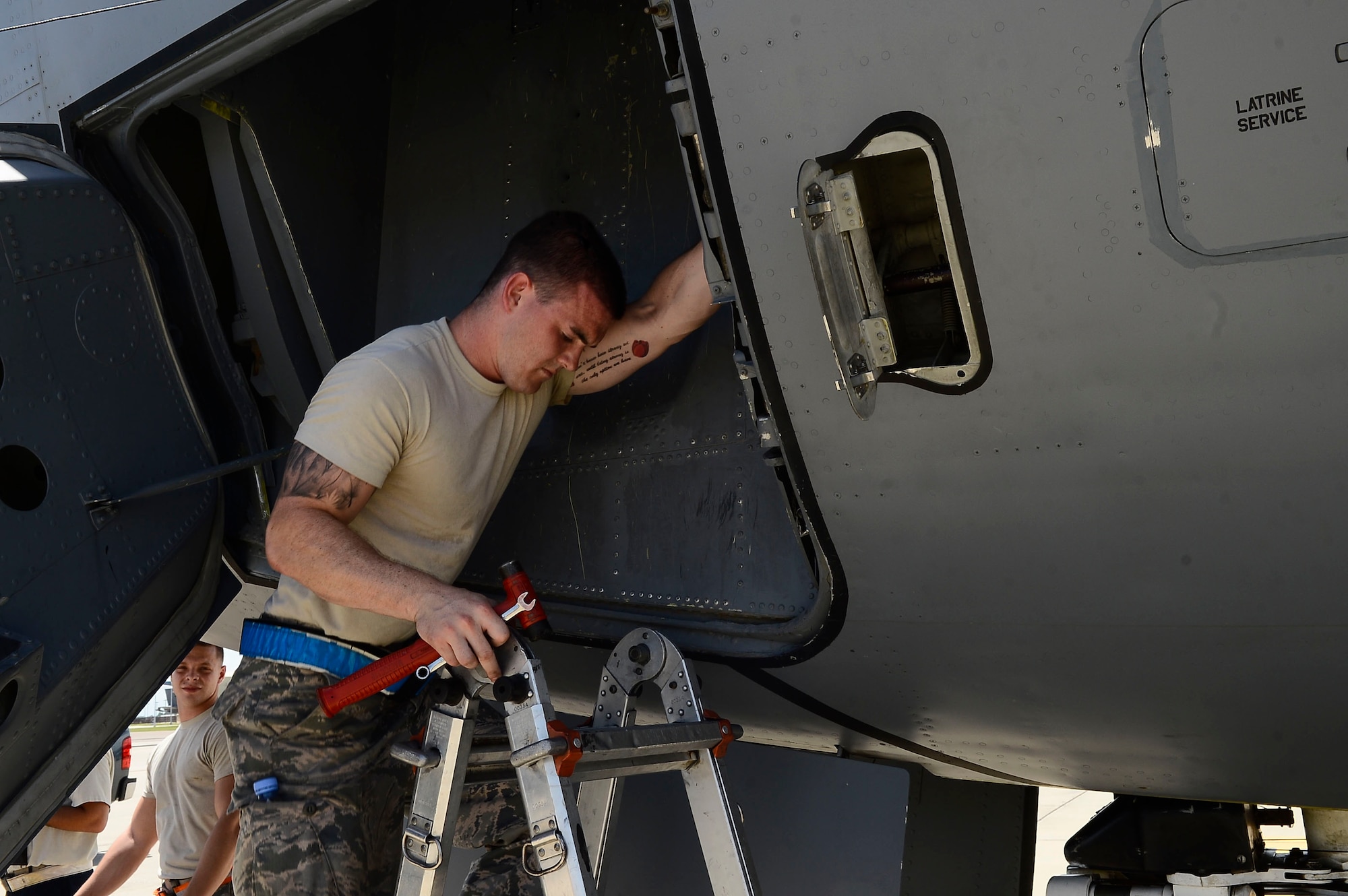 Senior Airman Stephen Rodgers, 6th Aircraft Maintenance Squadron crew chief, climbs down a ladder from the inside of the nose well at MacDill Air Force Base, Fla., Aug. 12, 2014. Rodgers was tightening bolts on an Improved Nose Wheel Snubber Brake. (U.S. Air Force photo by Airman 1st Class Tori Schultz/Released) 