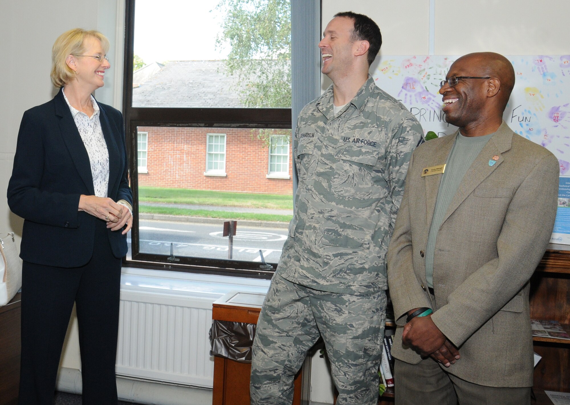Jeanette James, left, subcommittee on military personnel majority lead, shares a joke with U.S. Air Force Senior Master Sgt. Colin Richardson, center, 100th Force Support Squadron NCO in charge of readiness from Fakenham, England, and Kevin Mitchell, 100th FSS casualty assistance representative and survivor benefit plan counselor from New Haven, Conn., during a visit to the Airman and Family Readiness Center Aug. 19, 2014, on RAF Mildenhall, England. During the visit, James met with members of the A&FRC staff so they could introduce themselves and give an overview of their role on RAF Mildenhall. (U.S. Air Force photo/Gina Randall/Released)