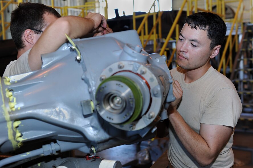U.S. Air Force Staff Sgt. Scott Okamoto, 33rd Helicopter Maintenance Unit crew chief, helps assemble the main transmission of an HH-60 Pave Hawk on Kadena Air Base, Japan, Sept. 3, 2014. The aircraft’s previous main transmission was found to be damaged during a phase inspection, requiring Airmen to assemble a new one. A phase inspection involves taking the aircraft apart, identifying and repairing any damage, replacing any unserviceable parts and putting it back together after every 600 hours of flying time. (U.S. Air Force photo by Airman 1st Class Zade C. Vadnais/Released)