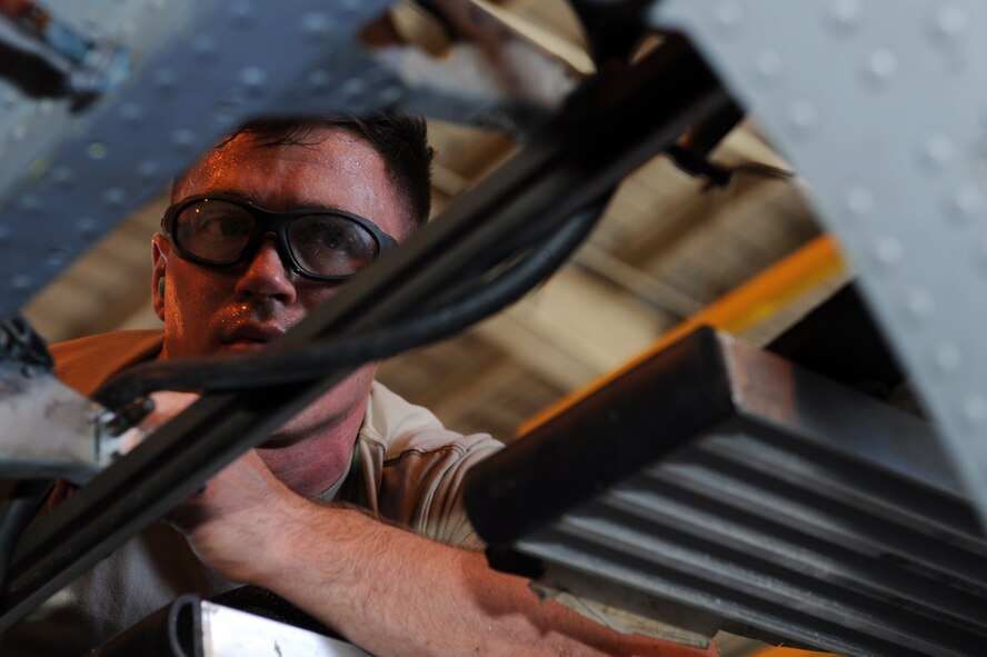 U.S. Air Force Airman 1st Class Robert Yenick, 18th Equipment Maintenance Squadron structural maintenance journeyman, installs rivets onto the sliding cargo door track of an HH-60 Pave Hawk on Kadena Air Base, Japan, Sept. 3, 2014. The installation was done as part of a phase inspection, which involves taking the aircraft apart, identifying and repairing any damage, replacing any unserviceable parts and putting it back together again every 600 hours of flying time. Frequent phase inspections are necessary in environments like Kadena where aircraft frequently come in contact with damaging salt water. (U.S. Air Force photo by Airman 1st Class Zade C. Vadnais/Released)