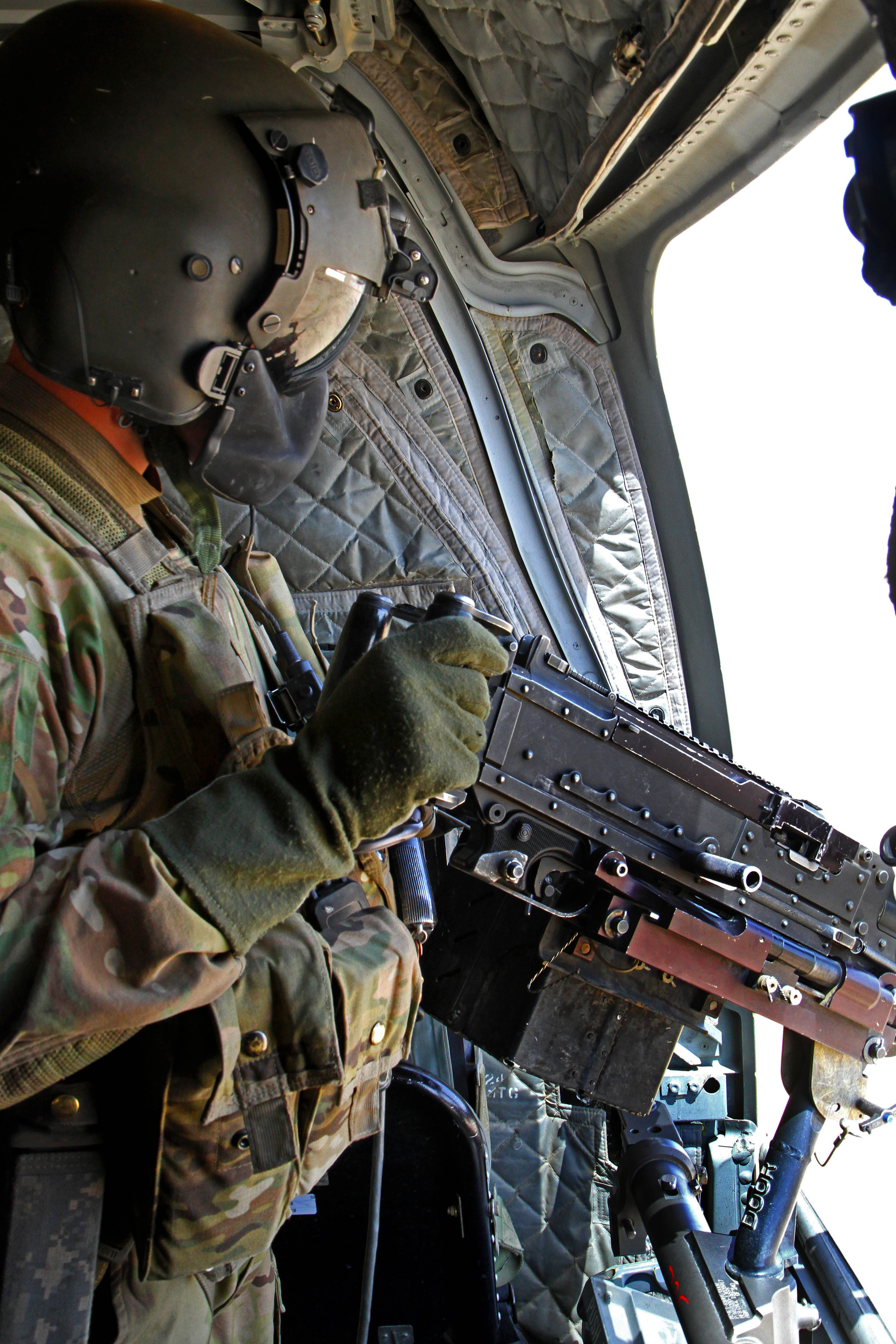 An Army door gunner prepares to conduct a test fire with a M240 ...