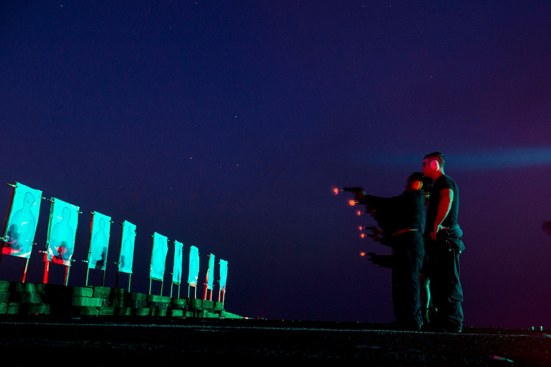 U.S. sailors fire M9 pistols during a ship's reaction force training course on the amphibious dock landing ship USS Gunston Hall in the Arabian Gulf, Aug. 26, 2014. 