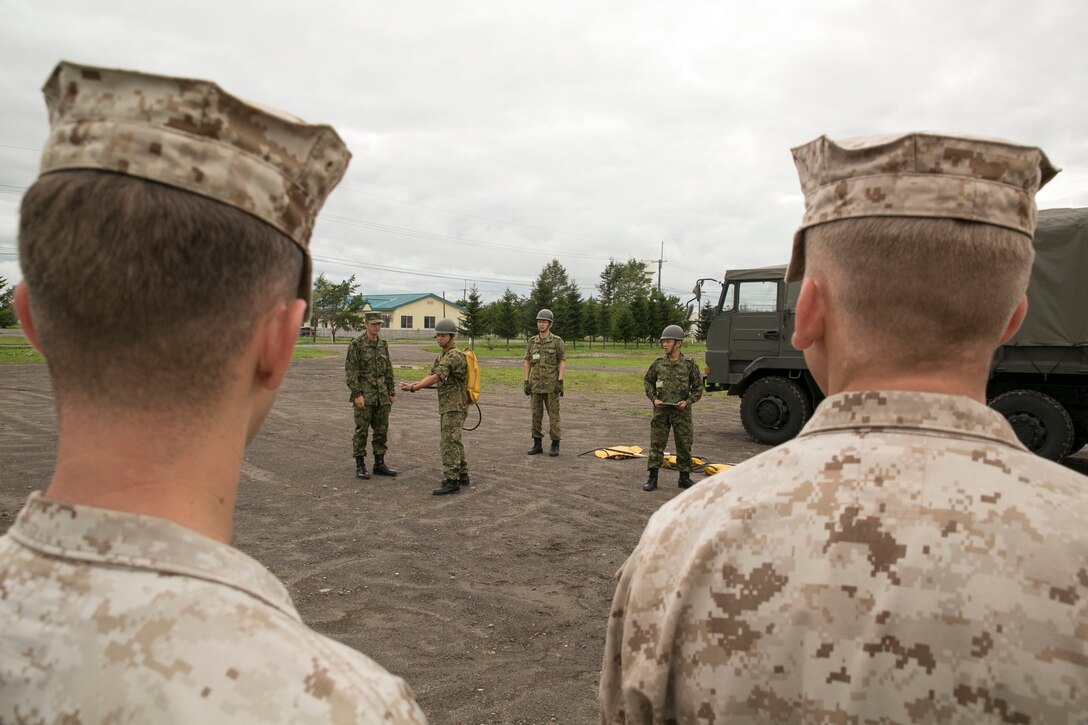 Marines observe Japan Ground Self-Defense Force personnel demonstrate how to properly use their firefighting equipment Aug. 21 at the Yausubetsu Maneuver Area during Artillery Relocation Training Program 14-2. During the live-fire portion of ARTP 14-2, Marines will use the firefighting equipment in case of a range fire. The service members are with the 5th Brigade, Northern Army, JGSDF. The Marines are with 3rd Battalion, 12th Marine Regiment, 3rd Marine Division, III Marine Expeditionary Force. (U.S. Marine Corps photo by Cpl. Matthew Manning/Released)