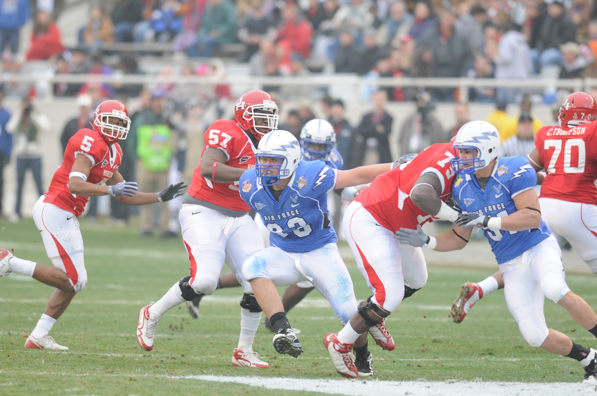 Air Force Falcons defensive lineman Ben Garland, left in blue uniform, and defensive end Myles Morales slip past members of the University of Houston Cougars during the Armed Forces Bowl Dec. 31, 2009, in Fort Worth, Texas. The Air Force Academy won the game 47-20. (U.S. Air Force photo/Bill Evans)