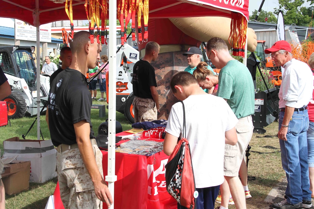 Marines with Marine Corps Recruiting Station Twin Cities help fair-goers during the Minnesota State Fair, with questions regarding the Marine Corps, August 22. Many Minnesotans stopped by the Marine Corps booth to learn about modern Marine Corps equipment and training. 
