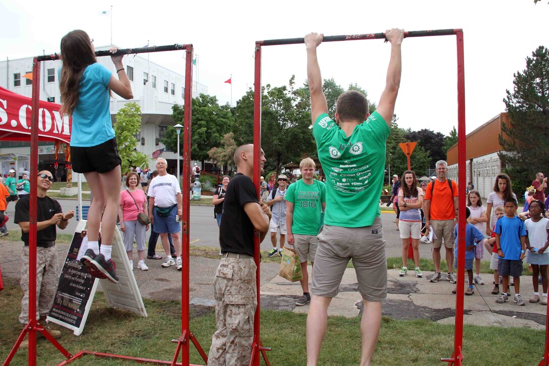 Minnesotan fair-goers conduct pull ups with Marine Corps Recruiting Station Twin Cities Marines, August 22. During the fair, thousands of Minnesotans stopped by the Marine booth to exercise the Marine Corps way. 