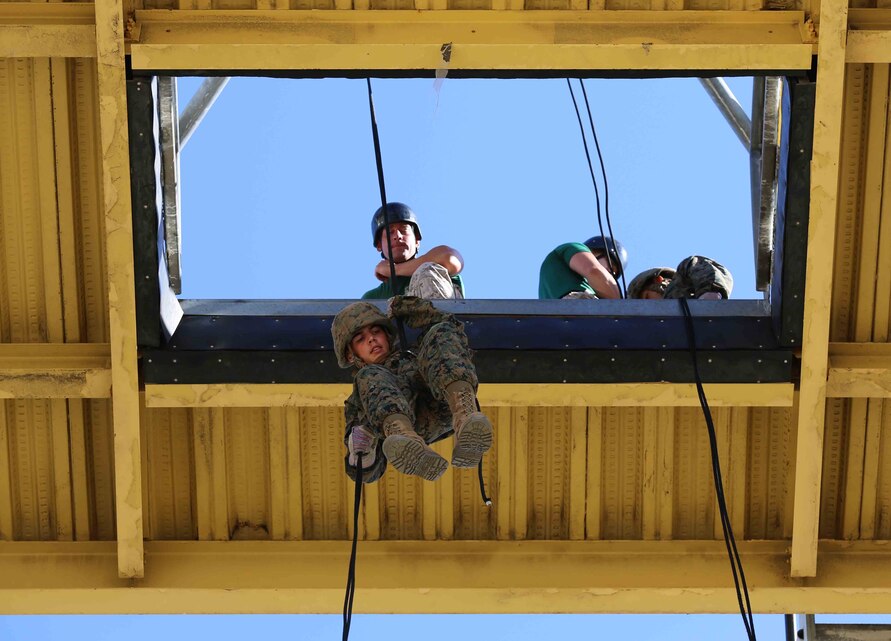 A recruit of Golf Company, 2nd Recruit Training Battalion, begins his descent from the "hell hole" during the fast roping exercise in recruit training at Marine Corps Recruit Depot San Diego, Aug. 29. The platform opens to a 60-foot drop, which simulates the opening Marines would use in the back of an aircraft to conduct an insertion when landing the aircraft is not possible.  