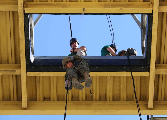 A recruit of Golf Company, 2nd Recruit Training Battalion, begins his descent from the "hell hole" during the fast roping exercise in recruit training at Marine Corps Recruit Depot San Diego, Aug. 29. The platform opens to a 60-foot drop, which simulates the opening Marines would use in the back of an aircraft to conduct an insertion when landing the aircraft is not possible.  