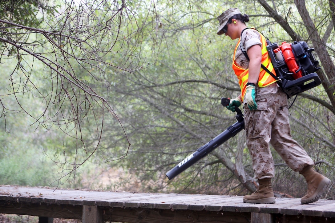 Pfc. Lyndelle Adam, an administrative specialist with Headquarters and Headquarters Squadron, clears a pathway of debris during a station wide cleanup aboard Marine Corps Air Station Miramar, Calif., Sept. 4. Approximately 250 Service members participated in the cleanup to promote a cleaner environment aboard the air station.