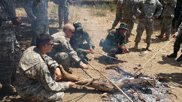 ASEM BAGUS, Indonesia (Sept. 5, 2014) - Soldiers from 2nd Battalion, 1st Infantry Regiment, 2nd Stryker Brigade Combat Team, 2nd Infantry Division and the Tentara Nasional Indonesia 411 Raider Infantry Battalion, cook pieces of snake meat during the Jungle Survival class of Garuda Shield 14. 