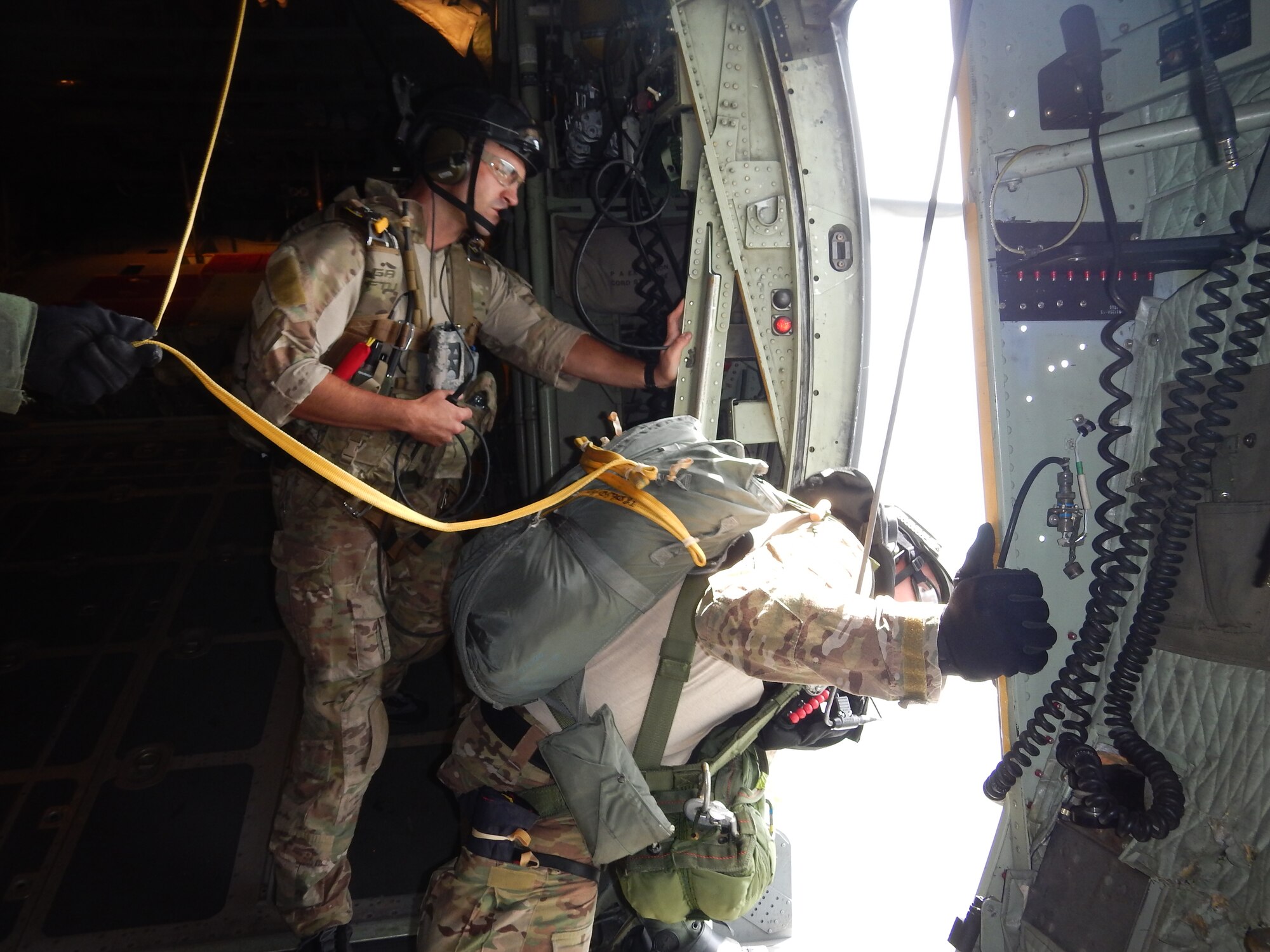 U.S. Air Force Tech. Sgt. Mark Gravino, 68th Rescue Flight instructor, observes and evaluates a student as he spots the target they will be jumping to during a Rescue Jumpmaster course at Patrick Air Force Base, Fla, Aug. 11, 2014. During the flight it is the student’s responsibility to direct the aircraft to the correct position prior to jumpers exiting the aircraft. (U.S. Air Force courtesy photo)