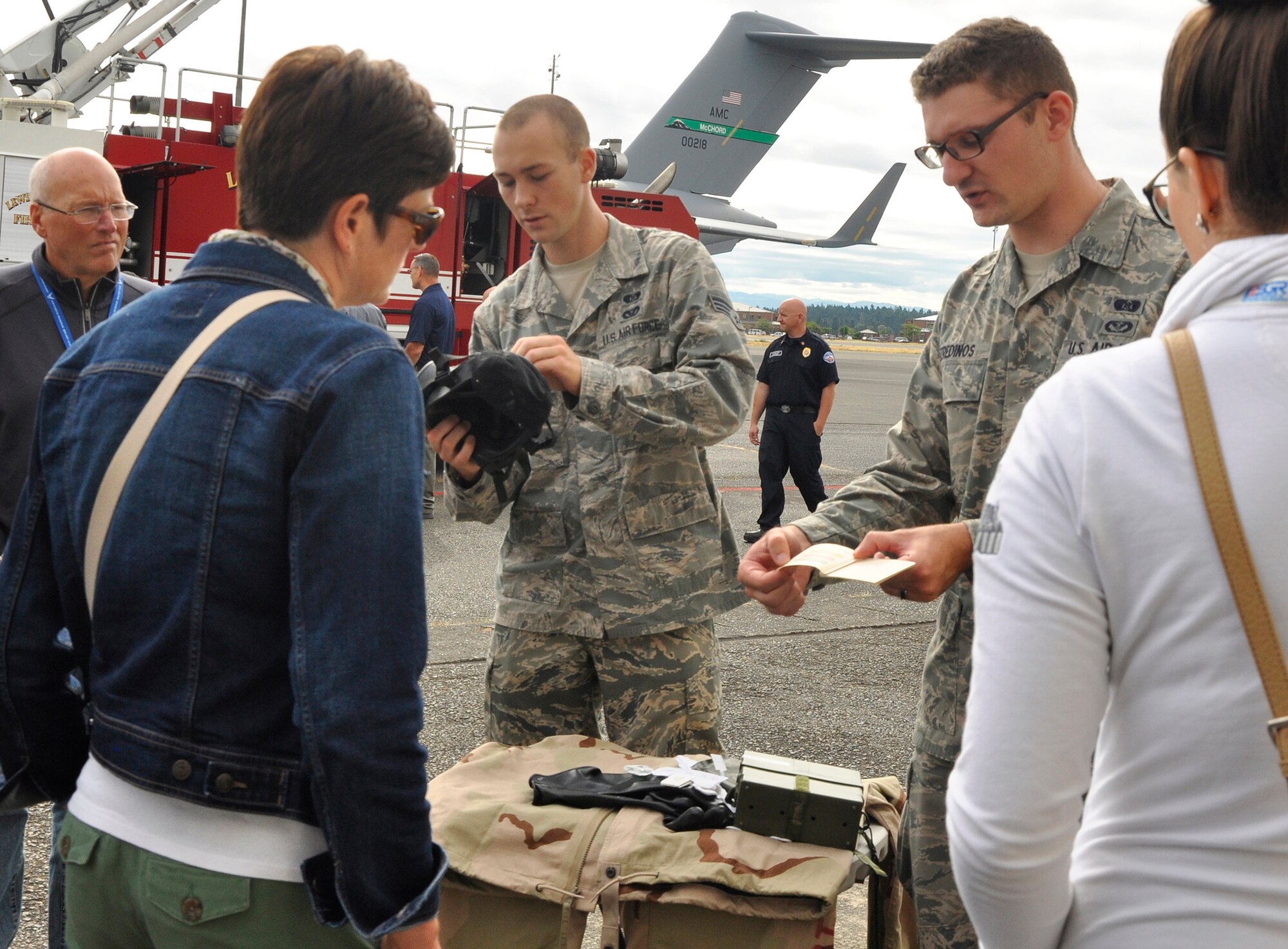 Senior Airman David Smith (center left), emergency management apprentice, and Senior Airman Alexis Feredinos (center right), emergency management journeyman both with the 446th Civil Engineer Squadron, explain how Reservists use various equipment to prevent casualties during an emergency situation on the flightline Aug. 29. Their presentation was part of a “Bosslift” tour, where 32 military support representatives, including business owners and local community leaders, spent a day on base to learn first-hand about the mission of the 446th Airlift Wing. Susan Coulter, a volunteer with the Employer Support of the Guard and Reserve, gave a presentation about ESGR before the group journeyed to the flight line, where members from the 446th Aeromedical Staging Squadron and 446th Aeromedical Evacuation Squadron loaded two mock critically-wounded patients onto a C-17 Globemaster III. Reservists from the 446th Security Forces Squadron and firefighters from the 446th CES also exhibited their expertise with the group. They later boarded a C-17, where Reserve pilots and loadmasters performed an air drop training mission. The tour ended after an orientation with the Air National Guard’s Western Air Defense Sector. (U.S. Air Force Reserve photo by Master Sgt. Minnette Mason)