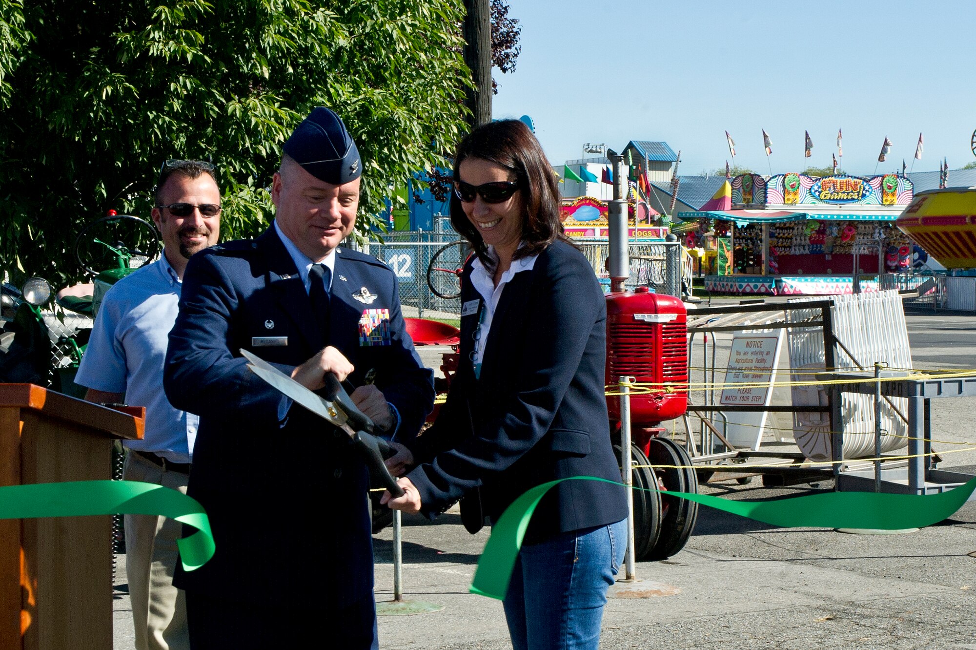 Col. Brian McDaniel, the 92nd Air Refueling Wing commander, joins Shelly O’Quinn, Spokane County Commissioner for District 2, in a ribbon cutting ceremony to commemorate the opening of the Spokane Interstate Fair in Spokane, Washington, Sept. 5, 2014. Spokane County's Interstate Fair is a 10-day event beginning the Friday after Labor Day each year. The Fair is held at the Spokane County Fair and Expo Center on the corner of Broadway and Havana, its location since 1952. (U.S. Air Force photo by Staff Sgt. Alexandre Montes/Released)