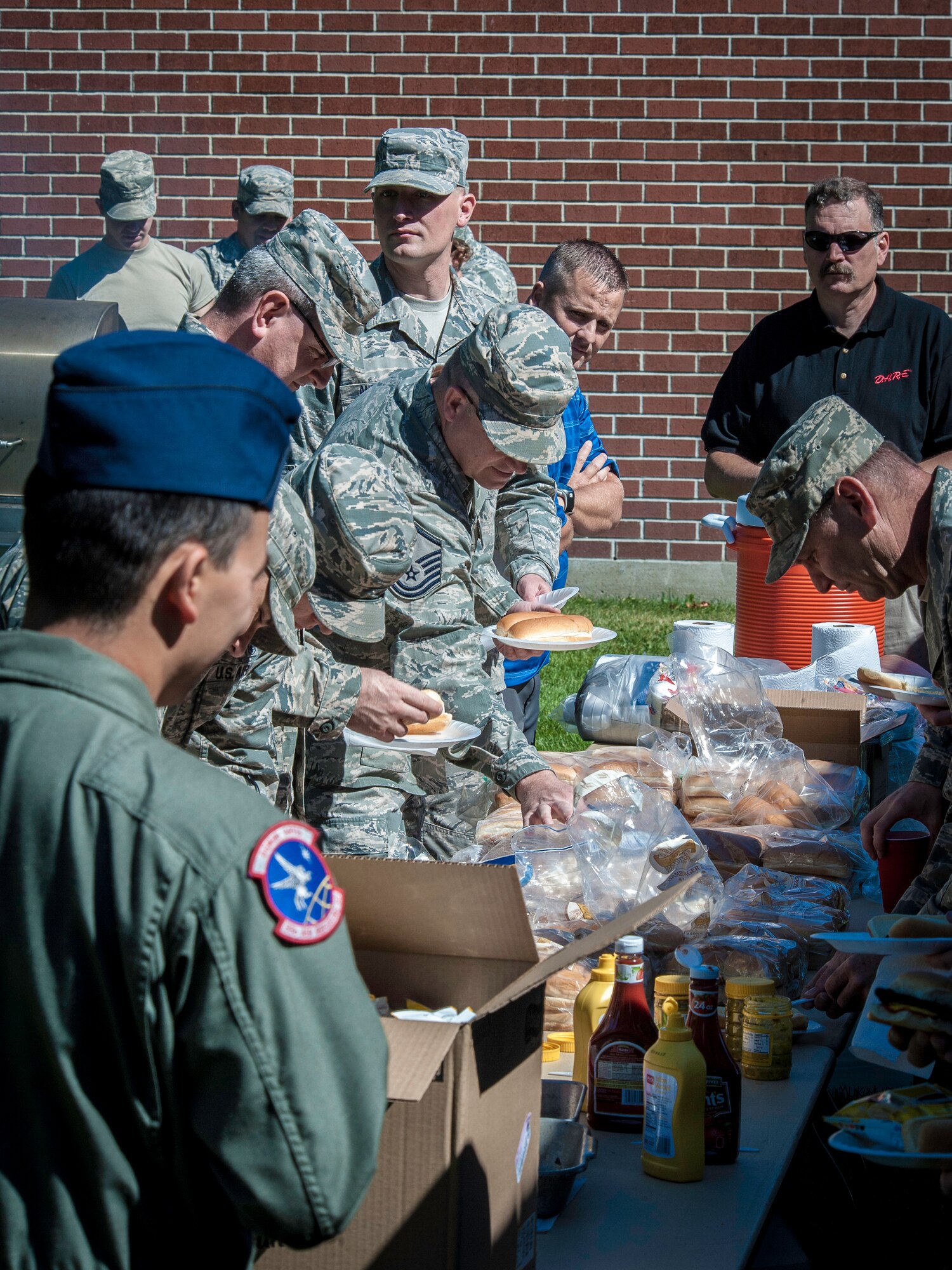 Team Fairchild members grab hamburgers and hotdogs during the DUI Fair at Fairchild Air Force Base, Washington, Sept. 5, 2014. Nearly 100 Participants were able to experience beer goggles during a field sobriety test, speak with legal and security forces representatives and take control of the impaired and distracted driving simulator. (U.S. Air Force photo by Staff Sgt. Benjamin W. Stratton/Released)