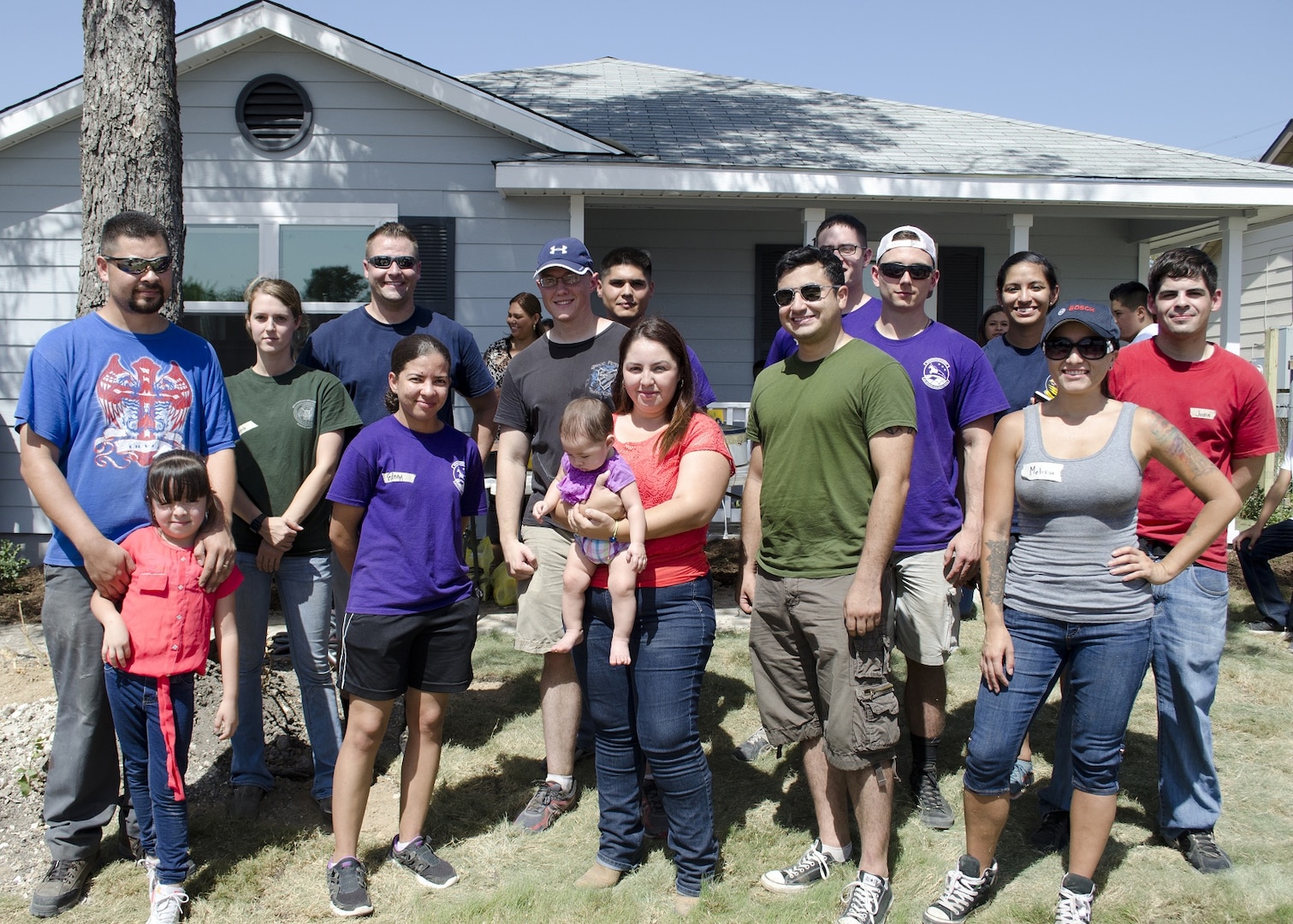 The Gonzalez family, recipients of a new home from Habitat for Humanity, stand with Air Force volunteers who helped make their home a reality in San Antonio, Texas, Aug. 22.