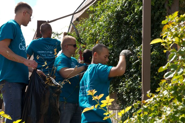 Members from Team Holloman work together to trim wall vines on a house during The Otero County Day of Caring in Alamogordo, N.M., Sept. 5. The Day of Caring is an event sponsored by the United Way of Otero County. Volunteers from Holloman and the local community perform various tasks for individuals who are unable to accomplish the tasks themselves or cannot afford to have the work done. Such tasks include fixing their homes, yards or other facilities, while also creating a strong relationship between Team Holloman and the surrounding communities. (U.S. Air Force photo by Staff Sgt. E’Lysia Wray/Released)