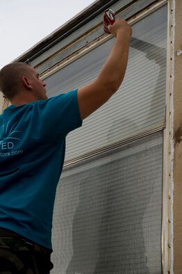 Senior Airman Jacob Toline, 49th Civil Engineer Squadron structural journeyman, applies a seal to a leaky window during The Otero County Day of Caring in Alamogordo, N.M., Sept. 5. The Day of Caring is an event sponsored by the United Way of Otero County. Volunteers from Holloman and the local community perform various tasks for individuals who are unable to accomplish the tasks themselves or cannot afford to have the work done. Such tasks include fixing their homes, yards or other facilities, while also creating a strong relationship between Team Holloman and the surrounding communities. (U.S. Air Force photo by Staff Sgt. E’Lysia Wray/Released)