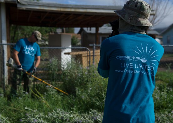 Members of Team Holloman remove weeds outside of a home during The Otero County Day of Caring in Alamagordo N.M., Sept. 5. The Day of Caring is an event sponsored by the United Way of Otero County. Volunteers from Holloman and the local community perform various tasks for individuals who are unable to accomplish the tasks or cannot afford to have the work done. Such tasks include fixing their homes, yards or other facilities, while also creating a strong relationship between Team Holloman and the surrounding communities. (U.S. Air Force photo by Senior Airman Leah Ferrante/Released)