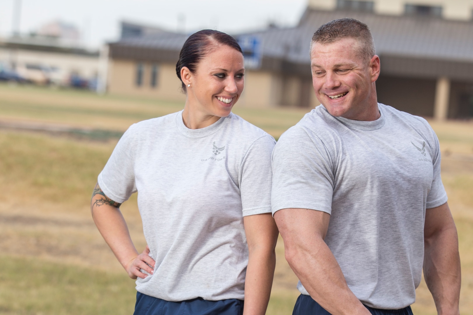 (Left) Staff Sgt. Tanisha Chaney, a 37th Training Support Squadron combat weapons instructor, and her husband, Tech Sgt. Eric Chaney, 37th TRSS NCO in charge of combat operations flight, smile at each other after a workout outside the Warhawk Fitness Center, Joint Base San Antonio-Lackland. (U.S. Air Force Photo by Joshua Rodriguez/Released) 