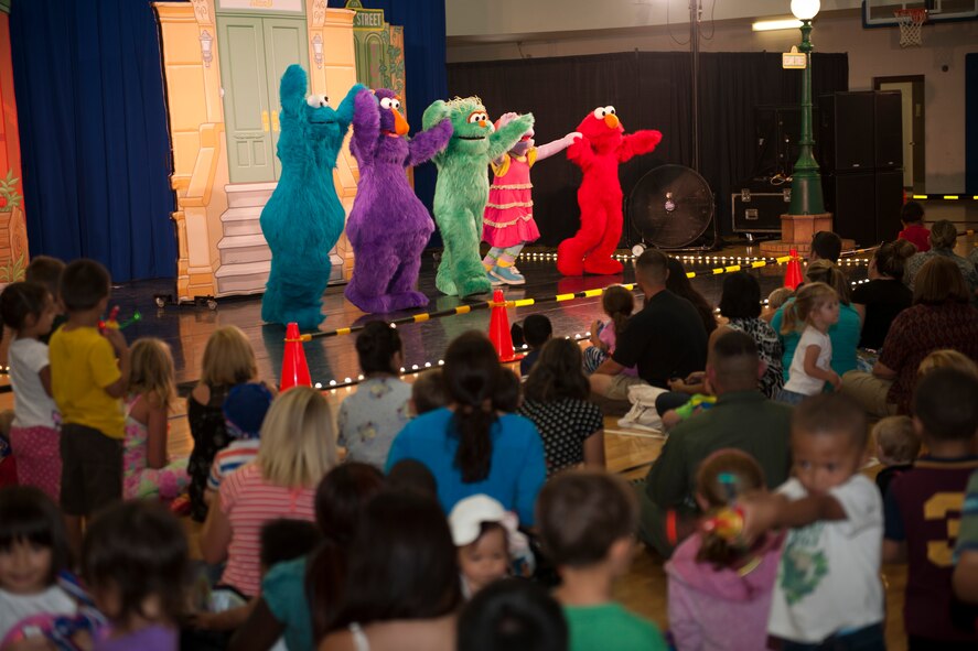 Team Holloman families watch as characters from the popular children’s show, Sesame Street, perform Sept. 3, at Holloman Air Force Base, N.M.  The United Service Organizations presented the Sesame Street/USO Experience for Military Families to help create lasting memories for service members and their families, while dealing with challenges of military life. The 30-minute show consisted of three songs where Sesame Street characters sang, danced and interacted with families in the audience. (U.S. Air Force photo by Airman 1st Class Emily A. Kenney/ Released)