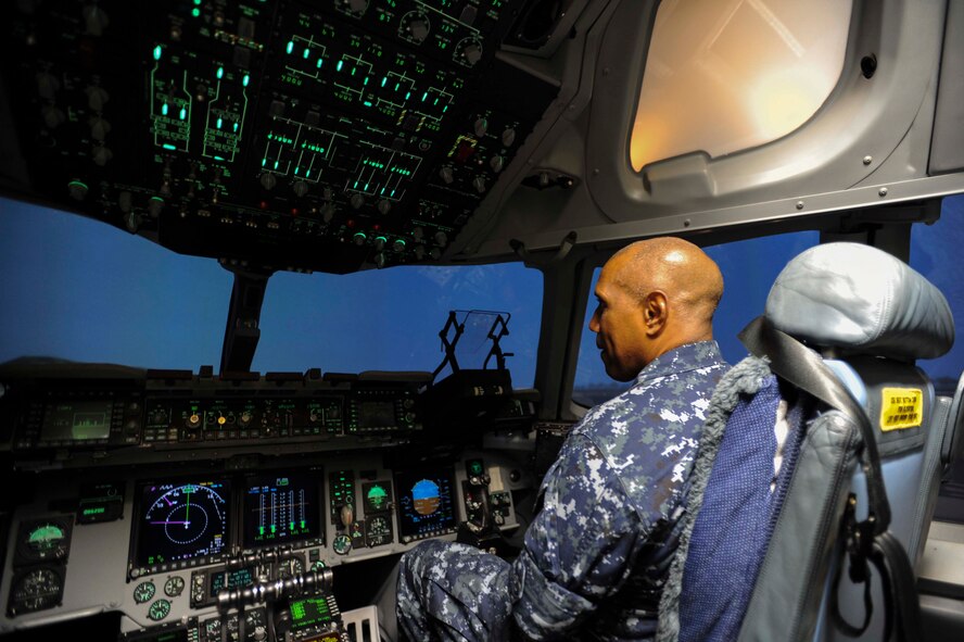 Navy Capt. Stanley Keeve, Jr., Joint Base Pearl Harbor-Hickam commander, prepares for a flight in the C-17 Globemaster III flight simulator as part of his immersion tour Sept. 4, 2014 at JBPHH. Keeve was briefed by 15th Wing leaders and visited numerous squadrons to become familiar with the wing mission and operations. (U.S. Air Force photo by 1st Lt. Andrea Dykes)