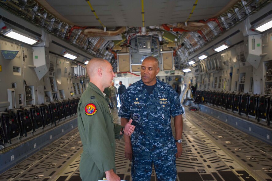 Capt. Reed Southard, 535th Airlift Squadron operations controller, highlights the capabilities of the C-17 Globemaster III to Navy Capt. Stanley Keeve, Jr., Joint Base Pearl Harbor-Hickam commander, during an immersion tour on the JBPHH flightline Sept. 4, 2014. Keeve was briefed by 15th Wing leaders and visited numerous squadrons to become familiar with the wing mission and operations. (U.S. Air Force photo by 1st Lt. Andrea Dykes)