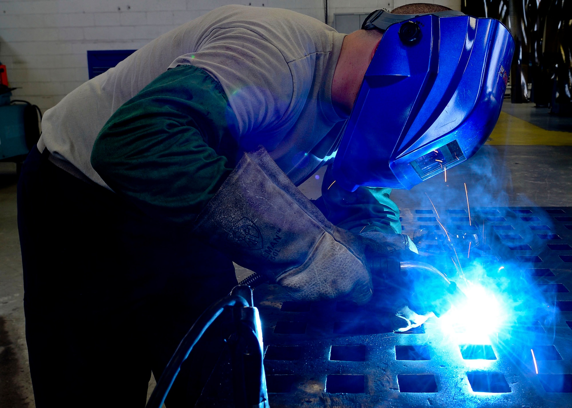 U.S. Air Force Senior Airman Spencer Chambers, 1st Maintenance Squadron aircraft metals technology journeyman, welds a piece of metal to manufacture parts for aircraft at Langley Air Force Base, Va., Sep. 3, 2014.  Chambers said he enjoys using various blue-prints to create parts to support units across the base.  (U.S. Air Force photo by Senior Airman Connor Estes/Released)