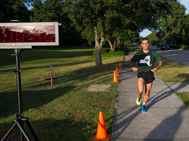 2nd Lt. John P. Montes, 628th Logistics Readiness Squadron, officer in charge of deployments and distribution, shows off his hometown New York Jets colors as he crosses the finish line of the 5k Fitness Challenge Sept. 5, 2014, at Joint Base Charleston, S.C. Montes was the first male finisher with a time of 16:40 and won a duffel bag filled with fitness items. More than 200 people participated in the run. (U.S. Air Force photo/Staff Sgt. William O'Brien)