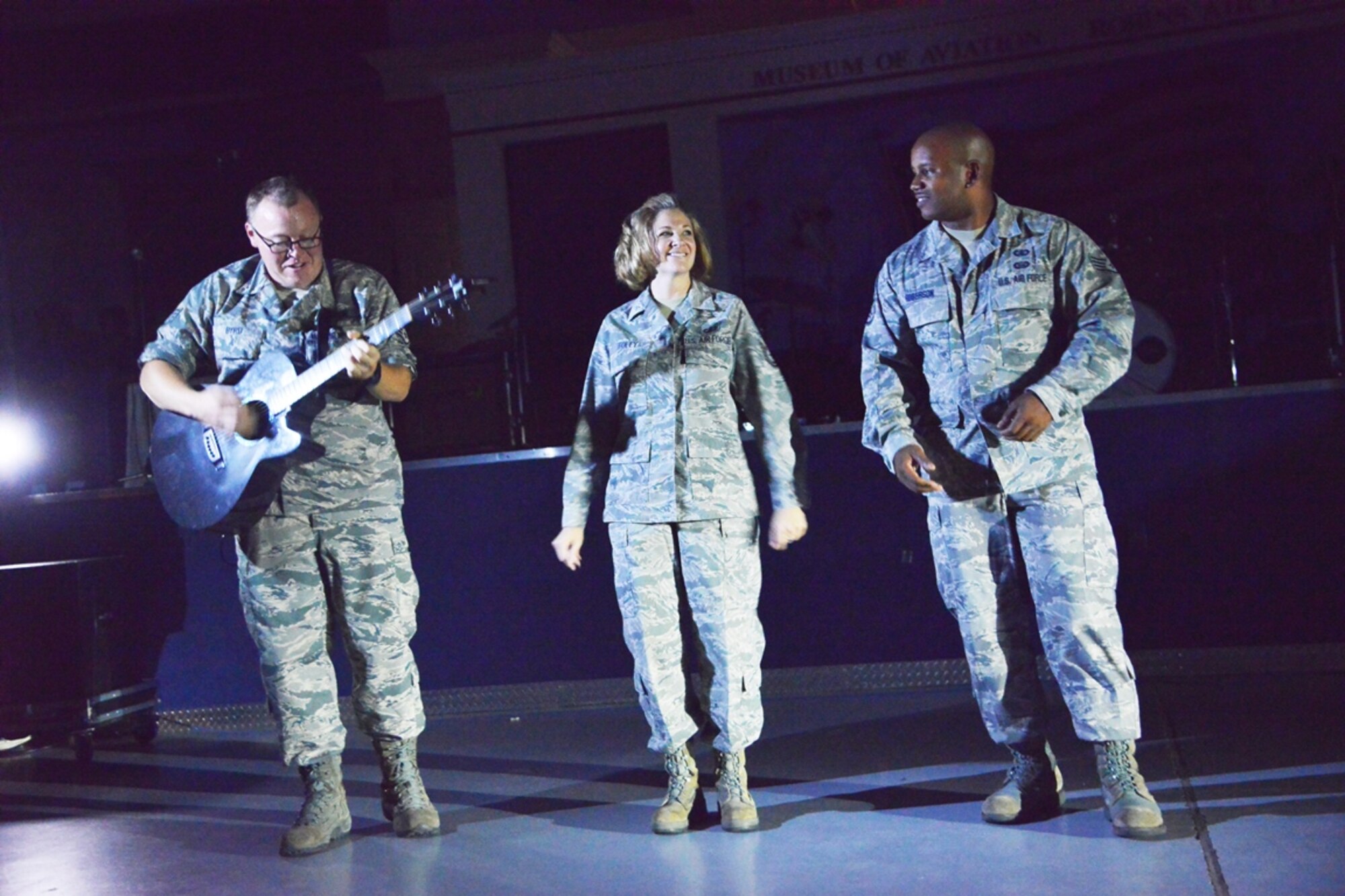 After a severe thunderstorm resulted in a power outage September 2, 2014, the "Sky Country" performance, had to be postponed, but Staff Sgt. Josh Byrd on guitar, Tech. Sgt. Christin Foley, vocalist and Staff Sgt. Henry Roberson, vocalist and bass player gave the large crowd of those who braved the storm a taste of what was to come. (U.S. Air Force photo by Ray Crayton)