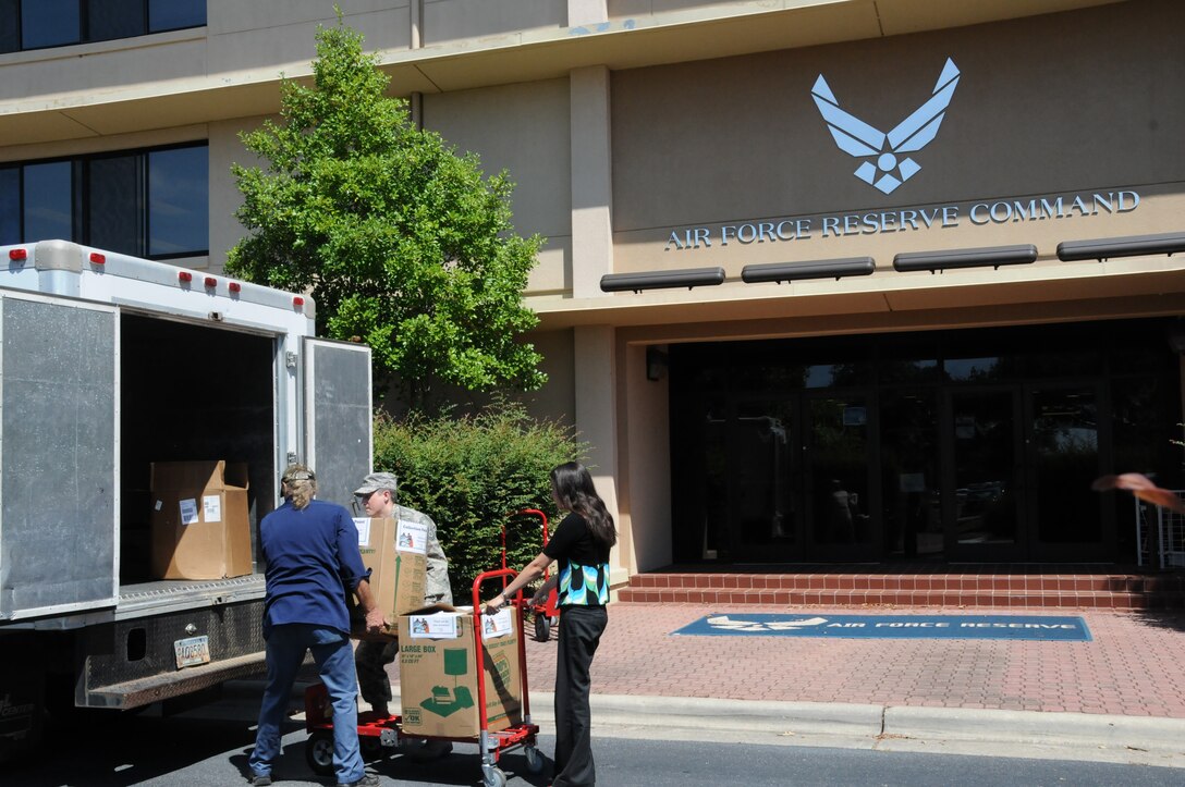 (Left to right) A volunteer from the Middle Georgia Community Foodbank; Tech. Sgt. Daniel Bricker, Tech. Sgt. Daniel Bricker, Air Force Reserve Command global command and control systems NCO in charge; and Rachel Cox, AFRC Communications Directorate resource advisor load Feds Feed Families Donations from AFRC Aug. 28. The more than 1,425 pounds of food collected will go through the Middle Georgia Community Foodbank to help feed people in need locally. (U.S. Air Force photo/ Master Sgt. Shanda L. De Anda)