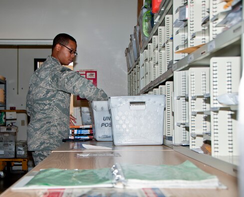 Senior Airman Tommy Armstrong, 60th Communications Squadron administrator, processes mail Aug. 26, 2014, in the Official Mail Center.  On average, the OMC processes 1,800 to 2,500 pounds of packages and official mail each week. (U.S. Air Force photo by Senior Airman Charles Rivezzo)