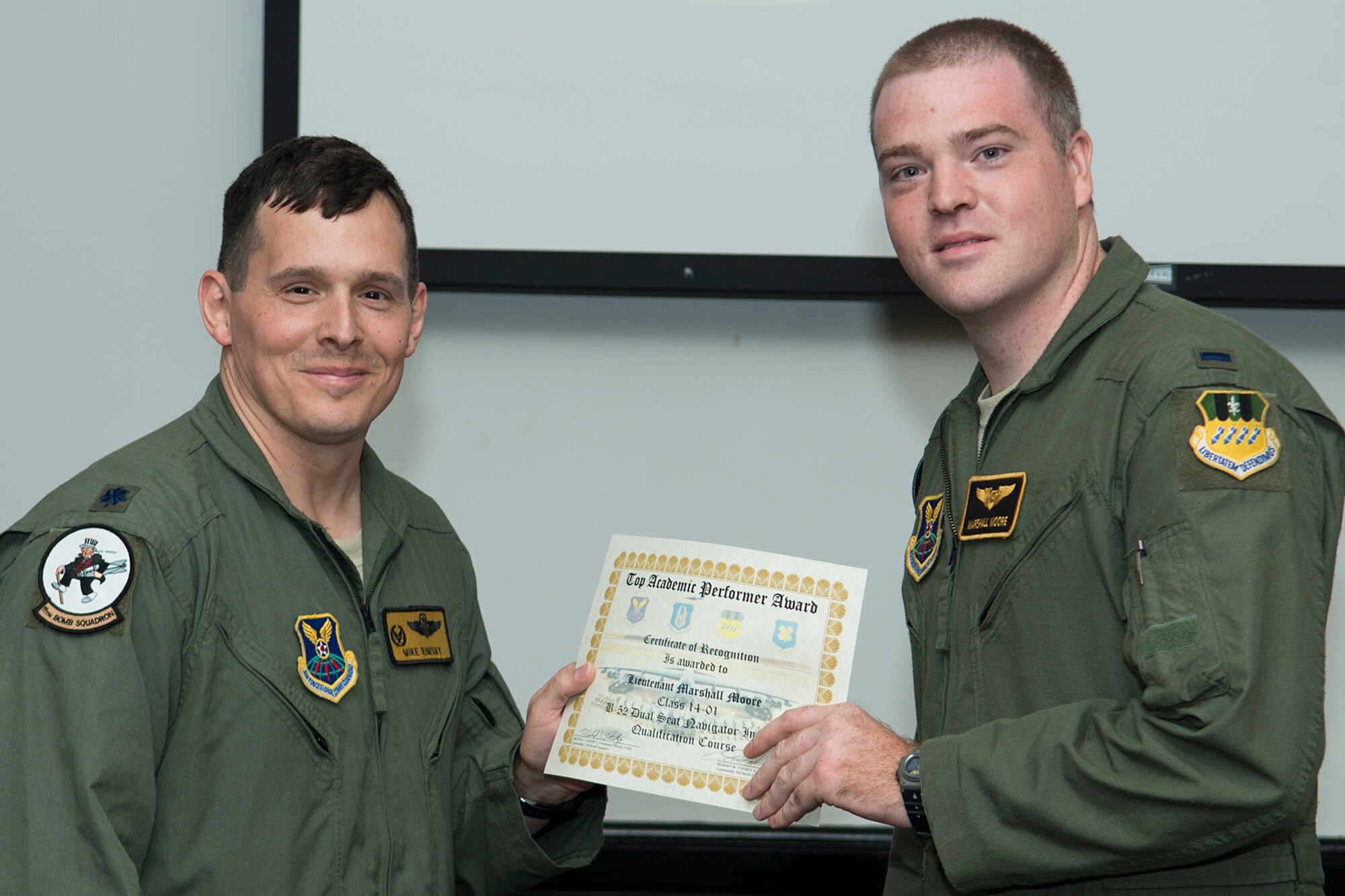 U.S. Air Force Lt. Col. Michael Rimsky, 11th Bomb Squadron commander, presents the Top Academic Performer Award to 1st Lt. Marshall Moore during a graduation ceremony, Aug. 28, 2014, Barksdale Air Force Base, La. Moore is a student of the B-52 Formal Training Unit class 14-01 and graduated with the highest academic scores in the Initial B-52 Dual Seat Navigator Qualification course. (U.S. Air Force photo by Master Sgt. Greg Steele/Released)