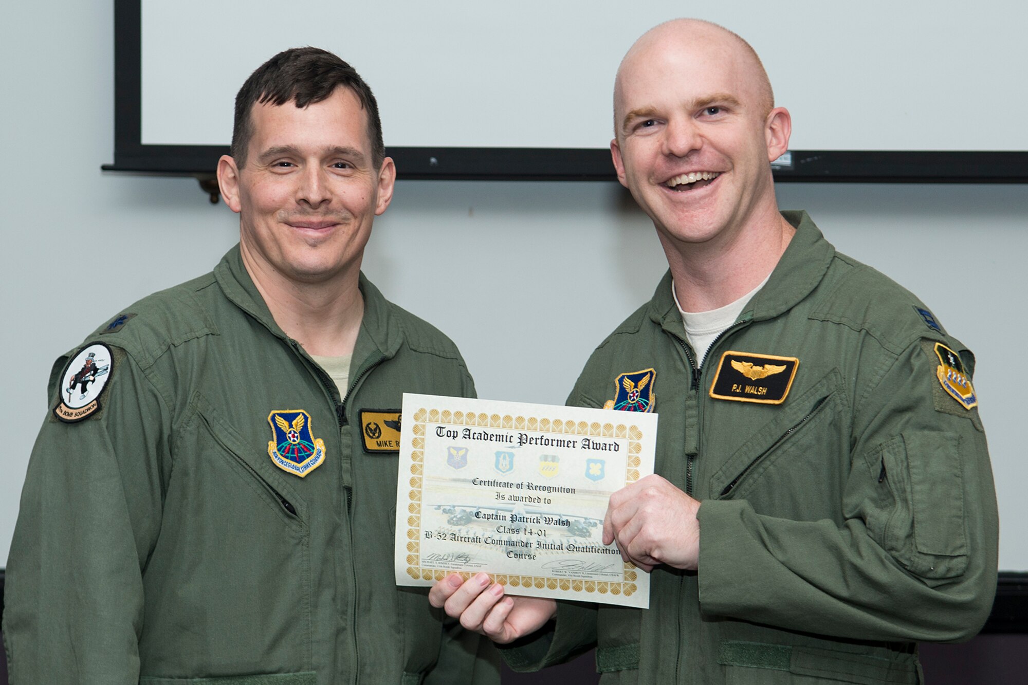 U.S. Air Force Lt. Col. Michael Rimsky, 11th Bomb Squadron commander, presents the Top Academic Performer Award to Capt. Patrick Walsh during a graduation ceremony, Aug. 28, 2014, Barksdale Air Force Base, La. Walsh is a student of the B-52 Formal Training Unit class 14-01 and graduated with the highest academic scores in the Initial Aircraft Commander Qualification course. (U.S. Air Force photo by Master Sgt. Greg Steele/Released)