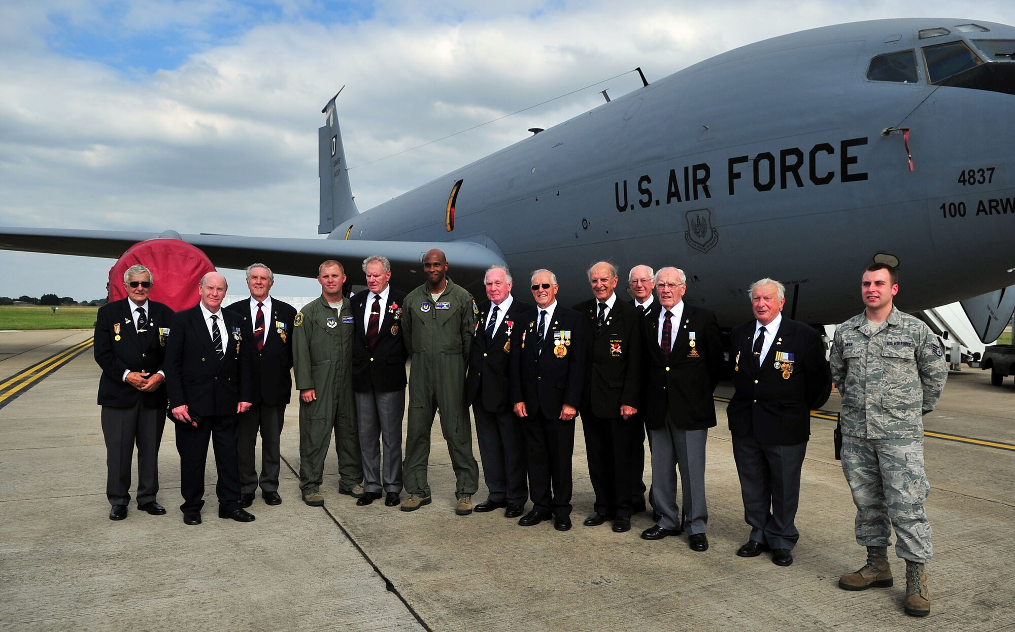 Airmen from RAF Mildenhall and British Korean War Veterans pose for a photo in front of a KC-135 Stratotanker on the flightline Sept. 2, 2014 on RAF Mildenhall, England. The veterans and their families also visited the 100th Security Forces Military Working Dogs for a demonstration. (U.S. Air Force/Senior Airman Christine Griffiths/Released)