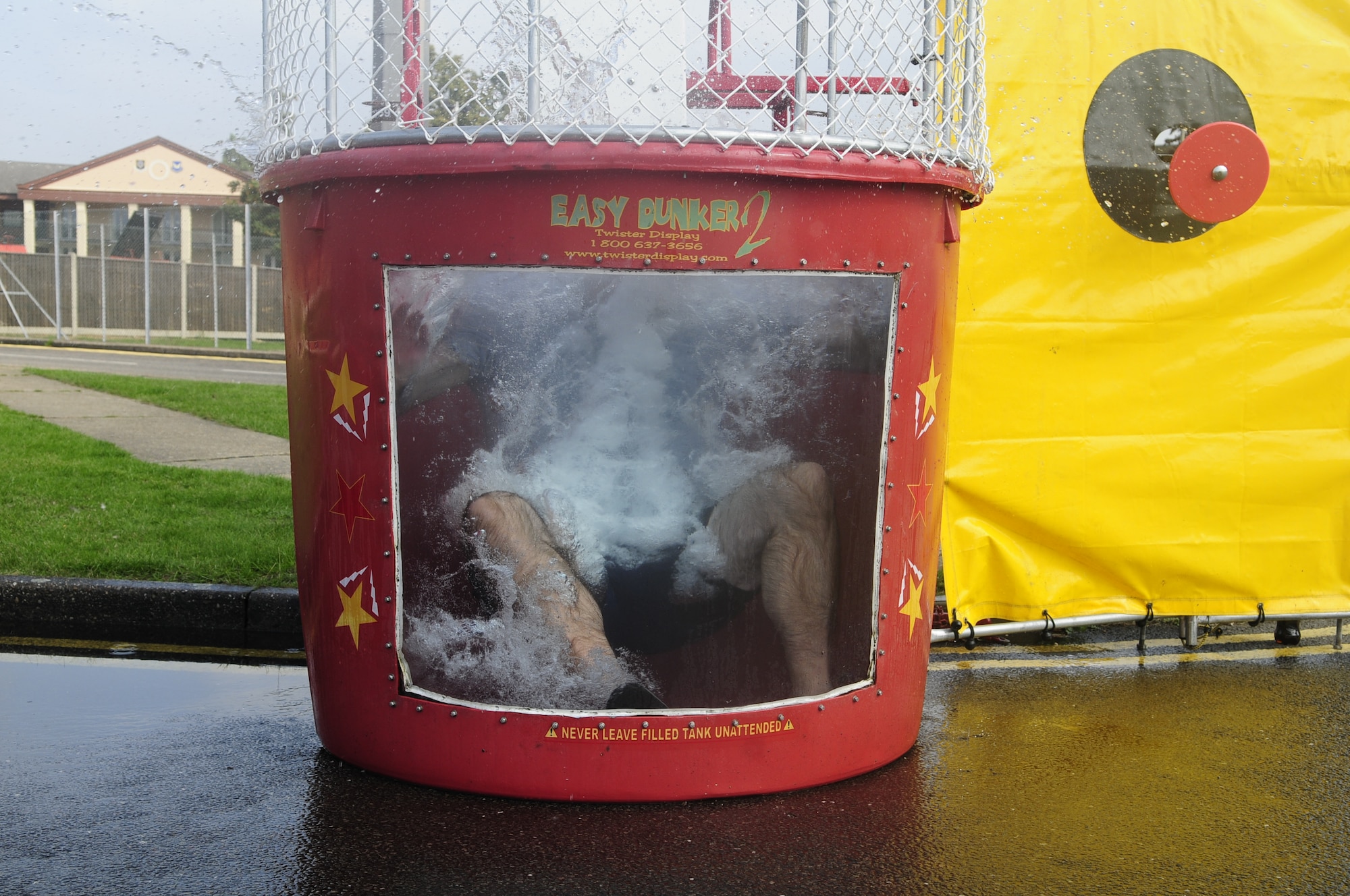 U.S. Air Force Col. Kenneth T. Bibb Jr., 100th Air Refueling Wing commander, gets plunged into the dunk tank Sept. 5, 2014, at the Unaccompanied Airmen Appreciation Day on RAF Mildenhall, England. Base leadership took turns getting dunked as Airmen threw balls to hit a target to send the commanders into a giant container of water. (U.S. Air Force photo/Airman 1st Class Preston D. Webb/Released)