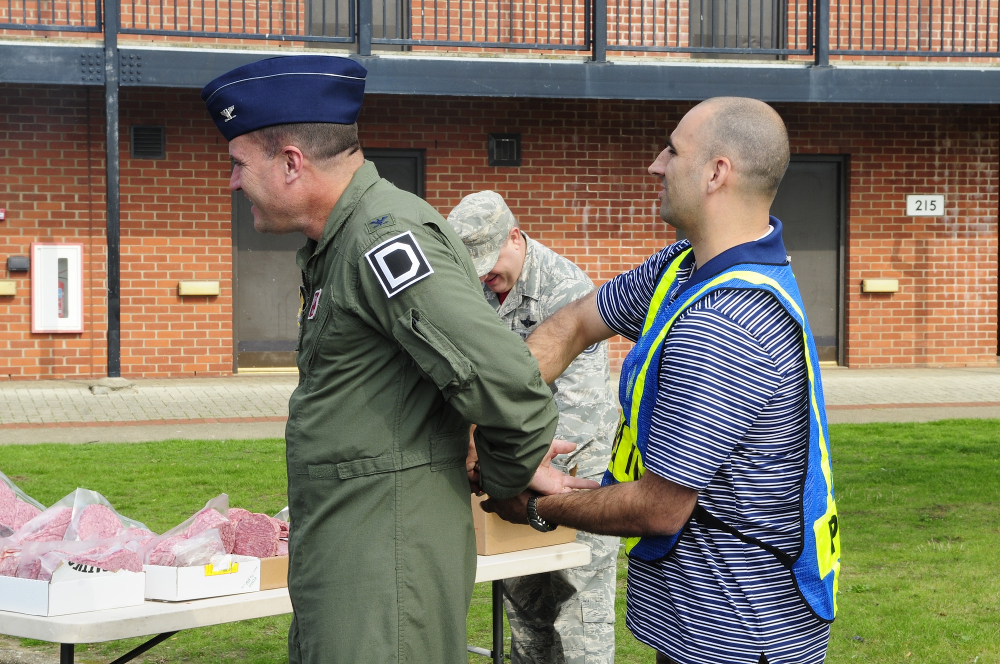 U.S. Air Force Col. Kenneth T. Bibb Jr., left, 100th Air Refueling Wing commander, simulates getting handcuffed by a 100th Security Forces Squadron member during a “jail and bail” as part of the Unaccompanied Airmen Appreciation Day Sept. 5, 2014, on RAF Mildenhall, England. Jail and bail is a fundraiser where people pay for votes to have others “arrested and jailed” for a short period of time. First sergeants, members of the Top Three Council and Chiefs Group organized the fourth annual UAAD to show their appreciation for the hard work done by Team Mildenhall Airmen. (U.S. Air Force photo/Karen Abeyasekere/Released)