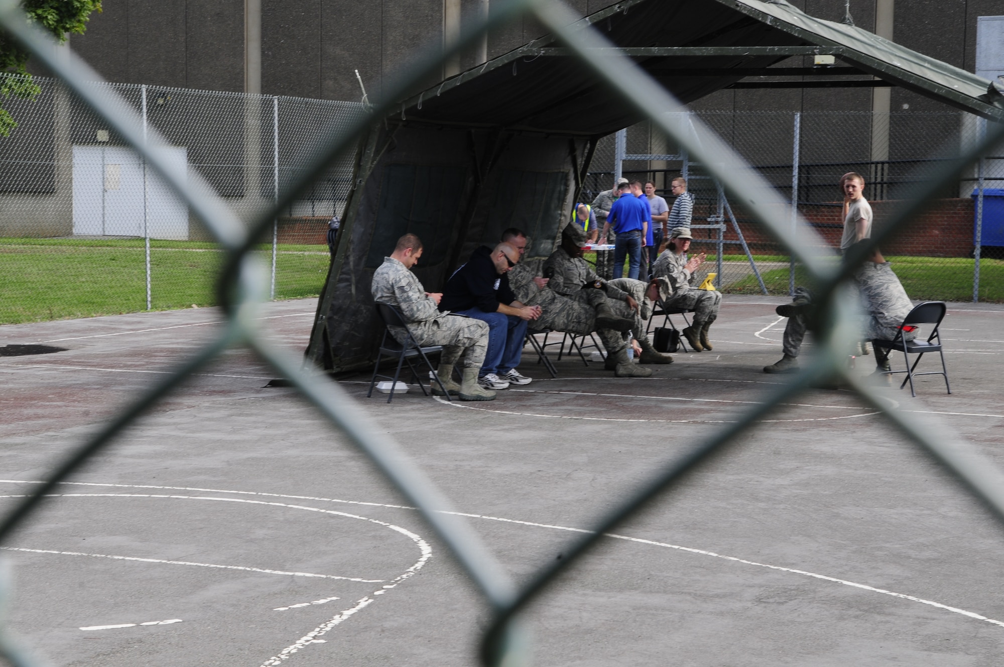 Team Mildenhall members serve their time after being “jailed” by friends and coworkers as part of the Unaccompanied Airmen Appreciation Day Sept. 5, 2014, on RAF Mildenhall, England. Jail and bail is a fundraiser where people pay for votes to have others “arrested and jailed” for a short period of time. The event also included a dunk tank, mock sumo wrestling and free food. (U.S. Air Force photo/Karen Abeyasekere/Released)