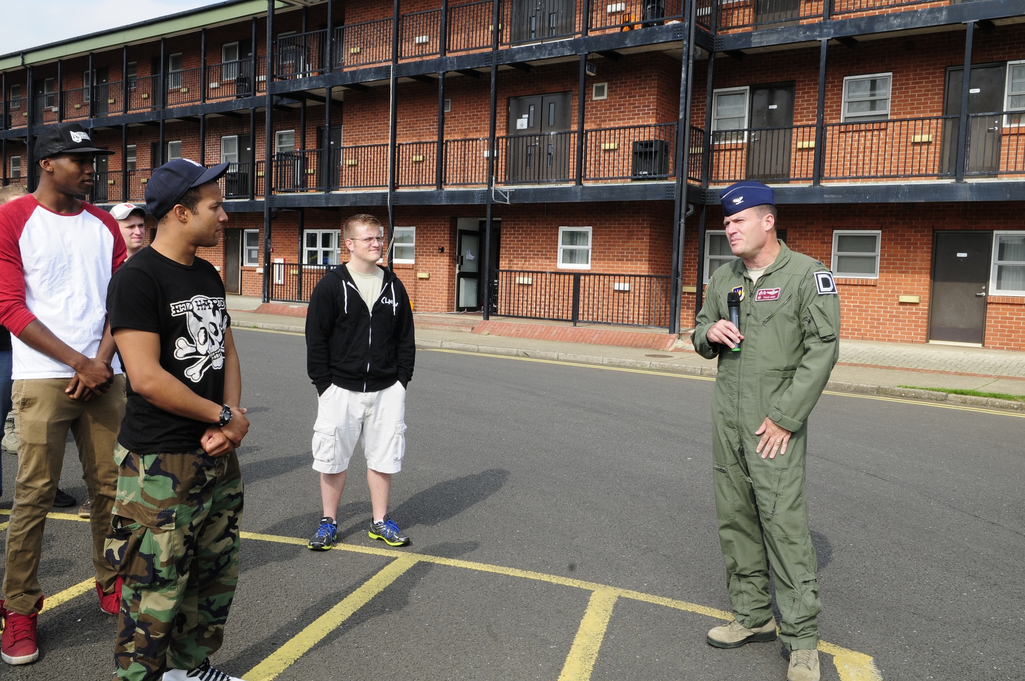 U.S. Air Force Col. Kenneth T. Bibb Jr., right, 100th Air Refueling Wing commander, gives opening remarks at the Unaccompanied Airmen Appreciation Day Sept. 5, 2014, on RAF Mildenhall, England. Various activities included a dunk tank, “jail and bail” (a fundraiser where people pay for votes to have others “arrested and jailed” for a short period of time), and mock sumo wrestling. (U.S. Air Force photo/Karen Abeyasekere/Released)

