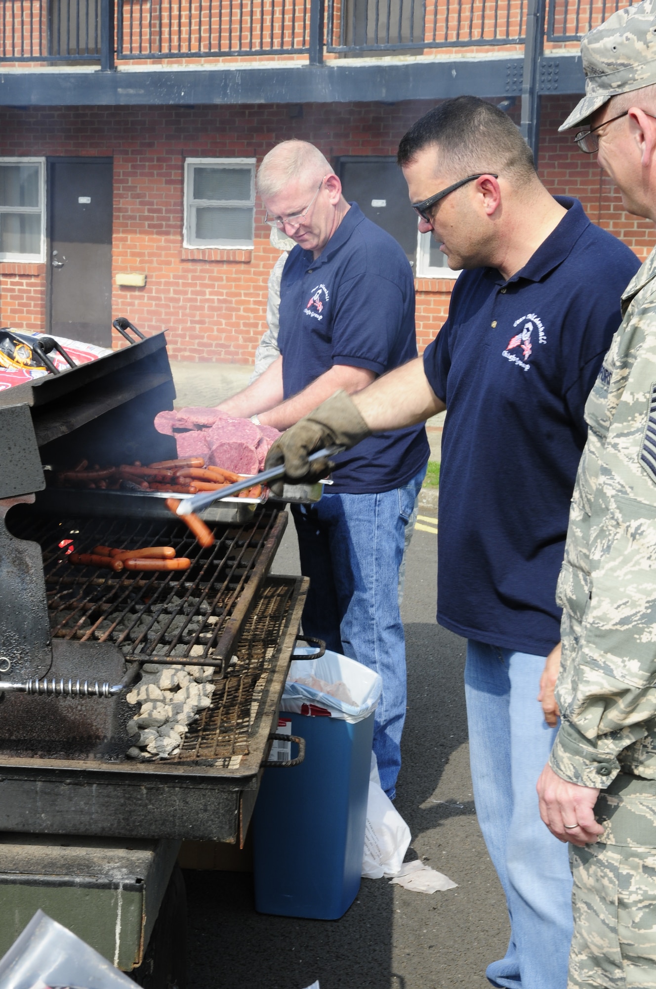 Members of the RAF Mildenhall Chiefs Group barbecue hamburgers and hot dogs during the Unaccompanied Airmen Appreciation Day at the Bob Hope Community Center parking lot Sept. 5, 2014, on RAF Mildenhall, England. First sergeants, members of the Top Three Council and Chiefs Group organized the fourth annual UAAD to show their appreciation for the hard work done by Team Mildenhall Airmen. (U.S. Air Force photo/Karen Abeyasekere/Released)