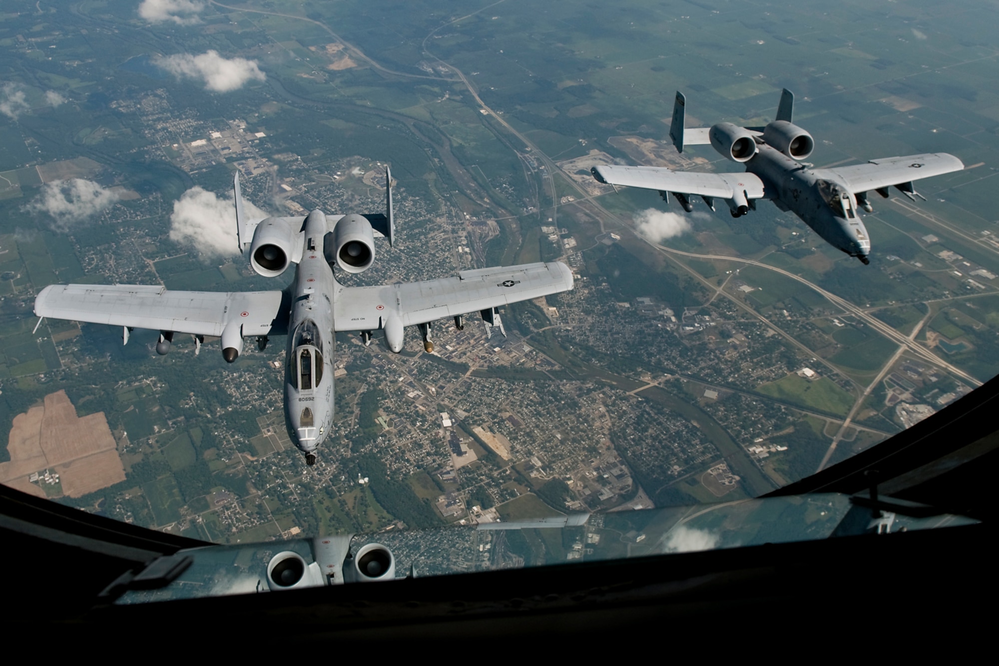 Two A-10 Thunderbolt II aircraft from the Air National Guard's 122nd Fighter Wing in Fort Wayne, Ind., fly behind a KC-135R Stratotanker aircraft from the Air Force Reserve's 434th Air Refueling Wing at Grissom Air Reserve Base, Ind., during a refueling mission over the Hoosier state Aug. 20, 2014. Indiana's two flying wings partnered together to fly 37 employers of guardsmen and reservists on a boss lift aimed at educating them about their employees' military service and responsibilities. (U.S. Air Force photo/Tech. Sgt. Mark R. W. Orders-Woempner) 
