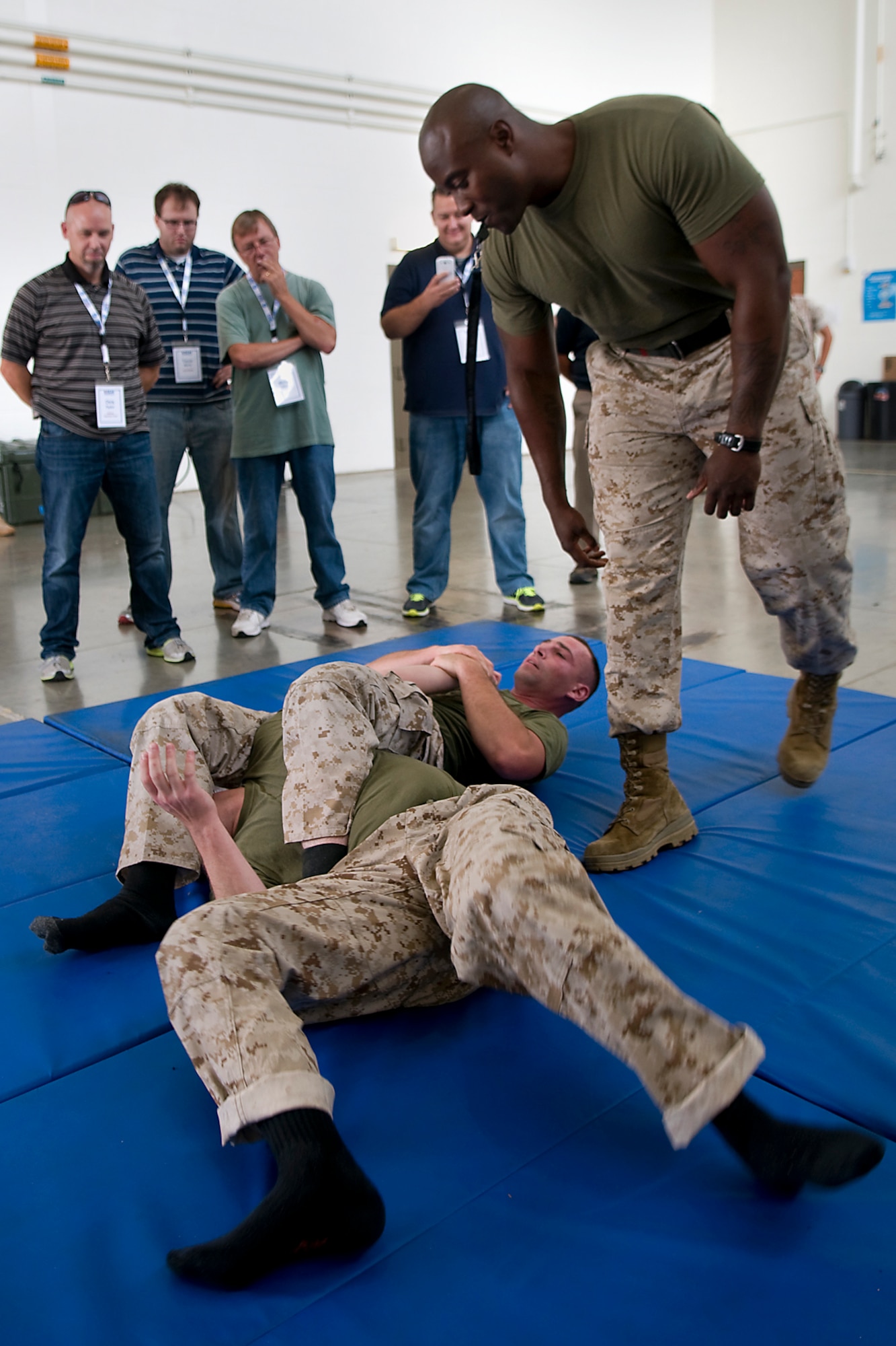 Marine Gunnery Sgt. Korey Wright, Detachment One, Communication Company, Combat Logistics Regiment 45, 4th Marine Logistics Group martial arts instructor, coaches two fellow marines during a training demonstration as reserve component employers  watch during a tour at Grissom Air Reserve Base, Ind., Aug. 19, 2014. Indiana's two flying wings partnered together with Grissom's Army Reserve and Marine Corps Reserve units to showcase the reserve components to 37 employers of guardsmen and reservists. (U.S. Air Force photo/Tech. Sgt. Mark R. W. Orders-Woempner) .
