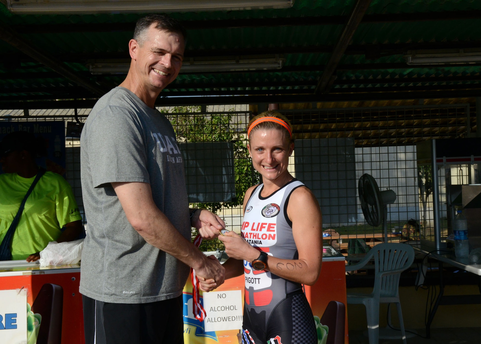 Tech. Sgt. Jessica Pigott, 717th Air Base Squadron logistics contract manager, receives a medal for being the first place female competitor during a sprint triathlon, Aug. 9, 2014, Incirlik Air Base Turkey. Pigott received U.S. Air Forces in Europe and Air Forces Africa,  female athlete of the year for 2014. (U.S. Air Force photo by Staff Sgt. Veronica Pierce/Released)